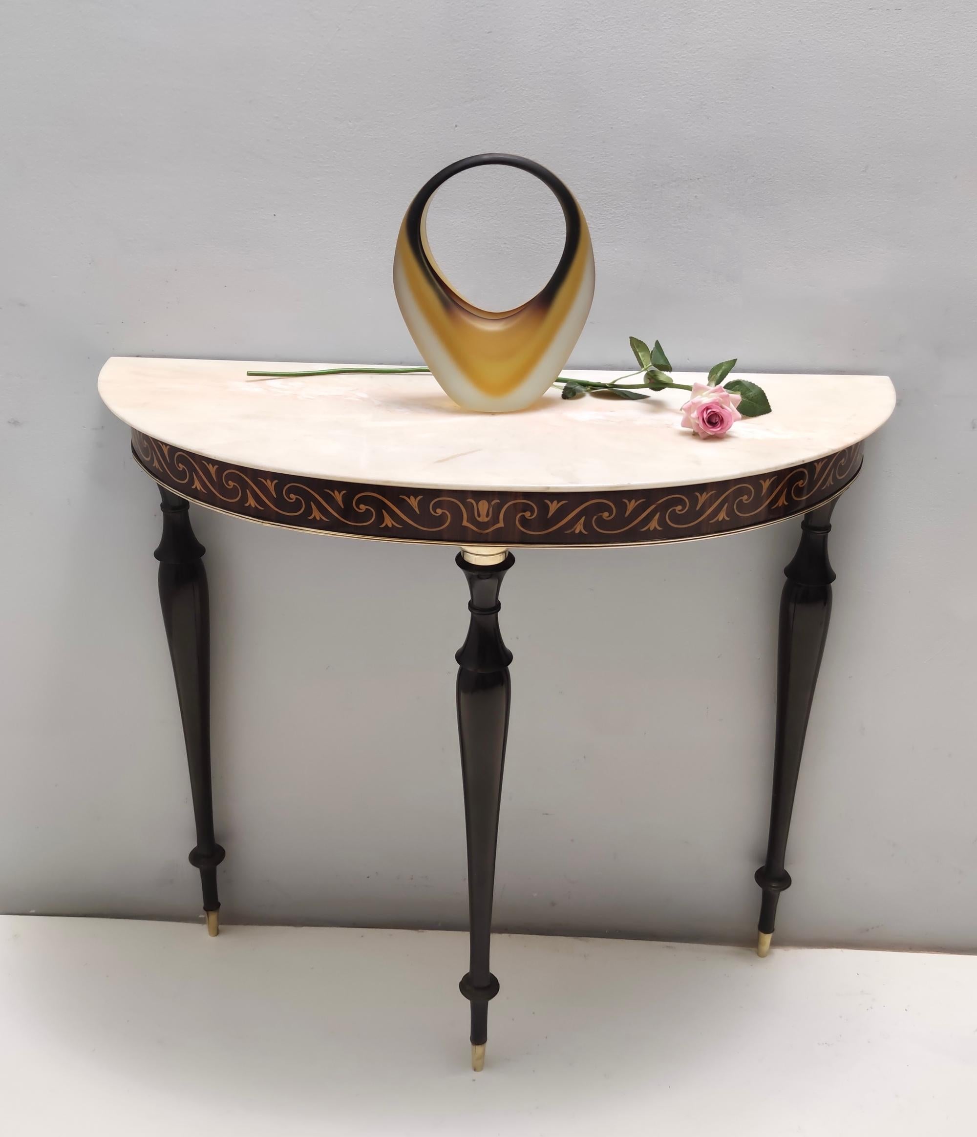 Made in Italy, 1950s.
It features a beech frame with black walnut and maple inlay work, brass elements and a demilune Portuguese pink marble top.
This console may show slight traces of use since it's vintage, but it can be considered as in excellent