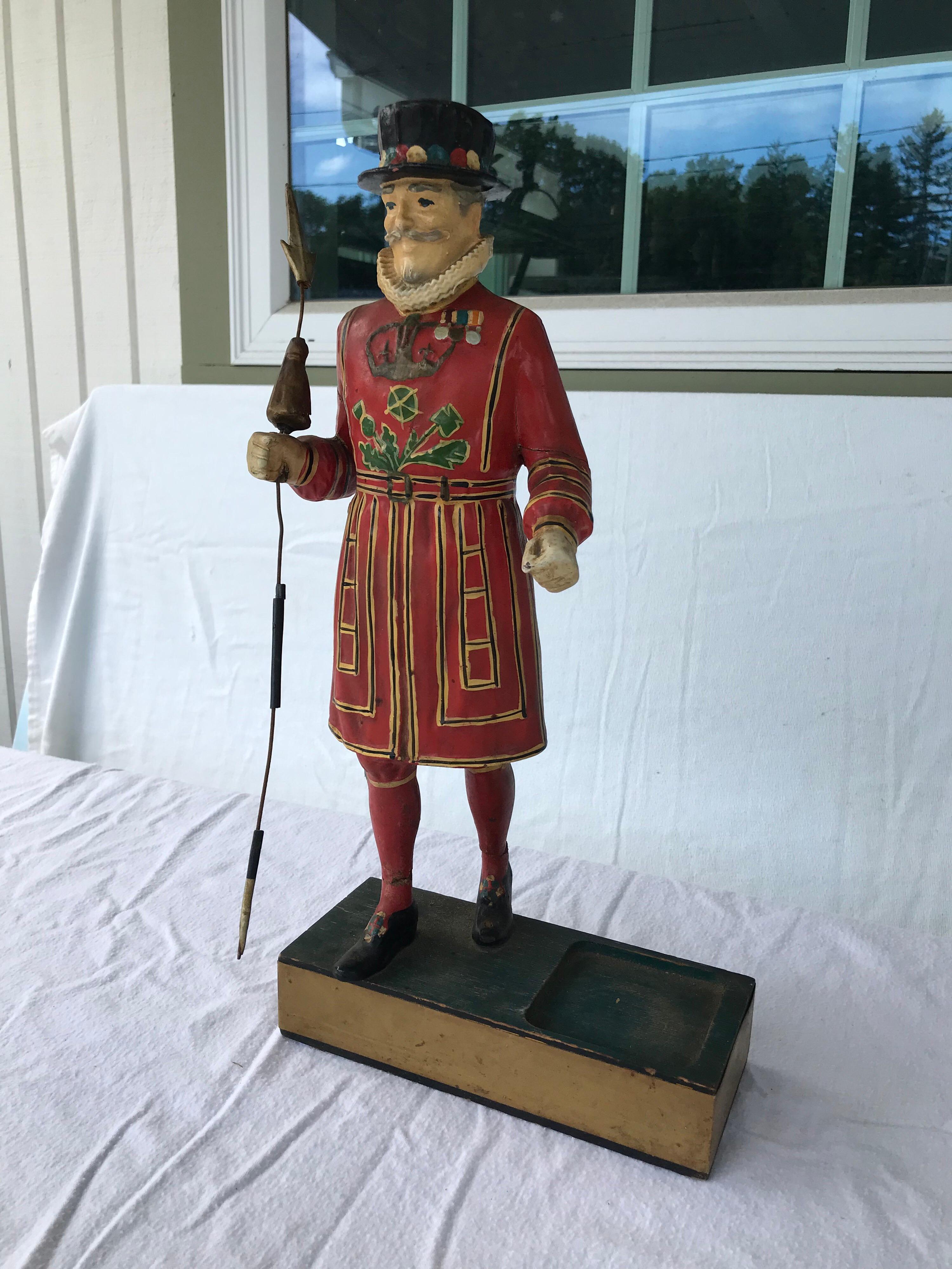 Vintage beefeaters gin bar display advertisement figurine. Wearing a yeoman (Queen's body guard) Warden Outfit and holding a quiver. There is space next to the figure for the bottle to be placed, circa 1950s. Please confirm dimensions prior to