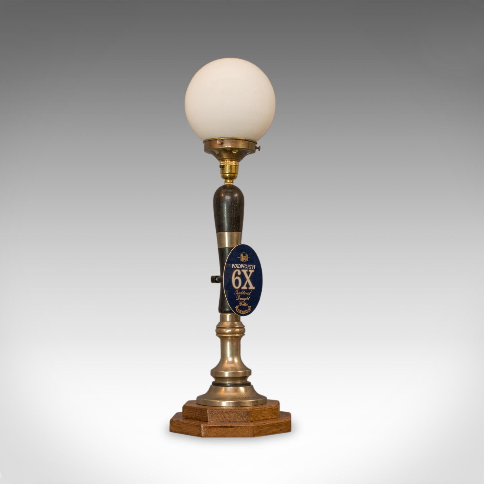 This is a vintage beer pump lamp. An English, bespoke handcrafted public house draught tap table light with an opaque, glass light shade.

In excellent condition, fully working with quality, opaque pendant lamp shade
Replete with genuine Wadworth