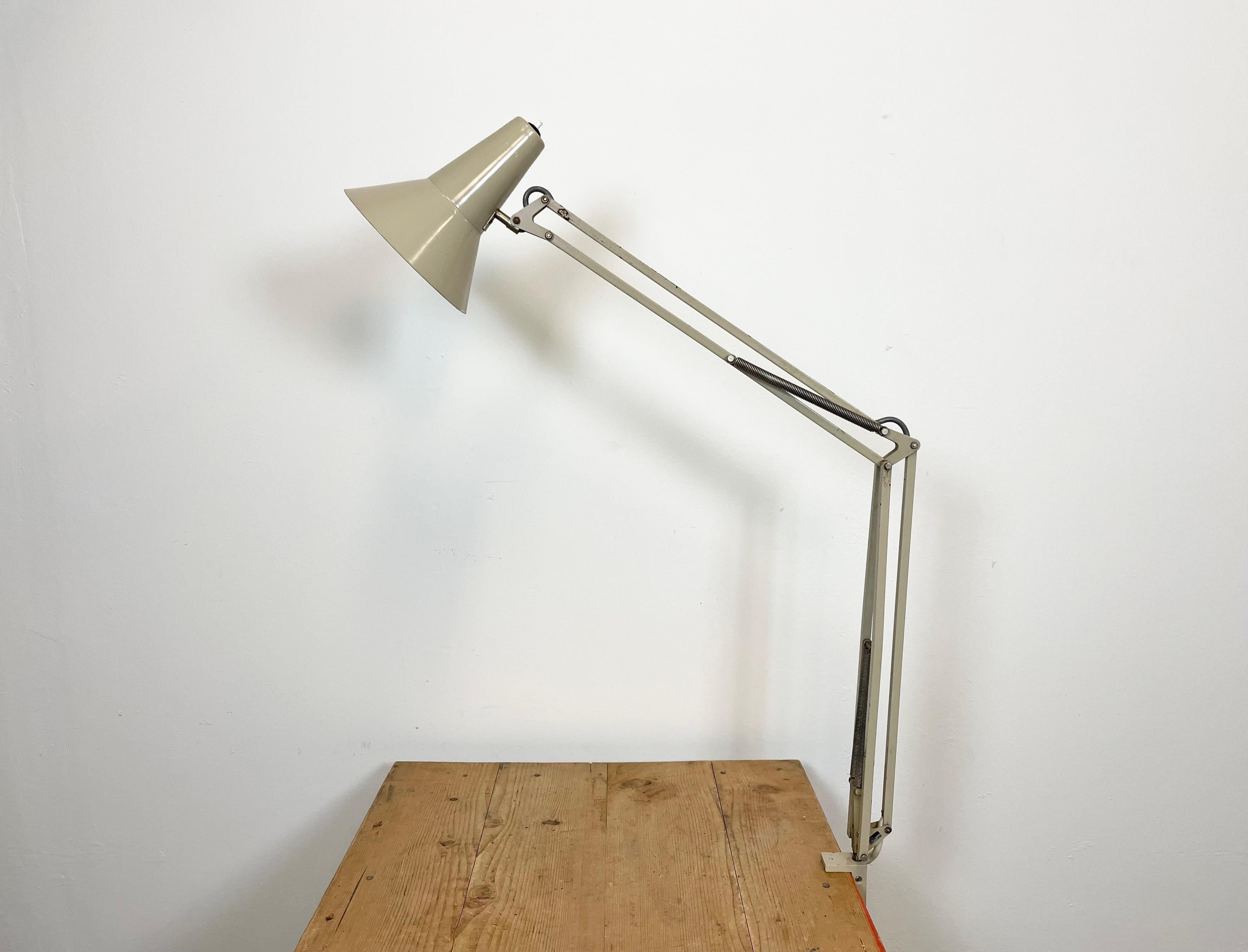 Vintage beige adjustable table lamp made by FAX in former Czechoslovakia during the 1970. It features an aluminium shade with original switch, an iron arm and clamp base.The socket requires standard E 27/ E 26 light bulbs. Original vintage condition.