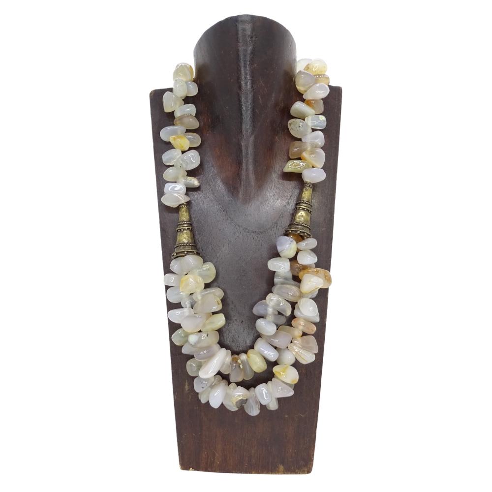 Elegant  magnifique et original collier de pierres de quartz tumbled et de détails en bronze antique, y compris le fermoir. Il est conçu par la marque française Césarée.

Le design présente une chaîne de grosses perles de quartz blanchâtre autour du