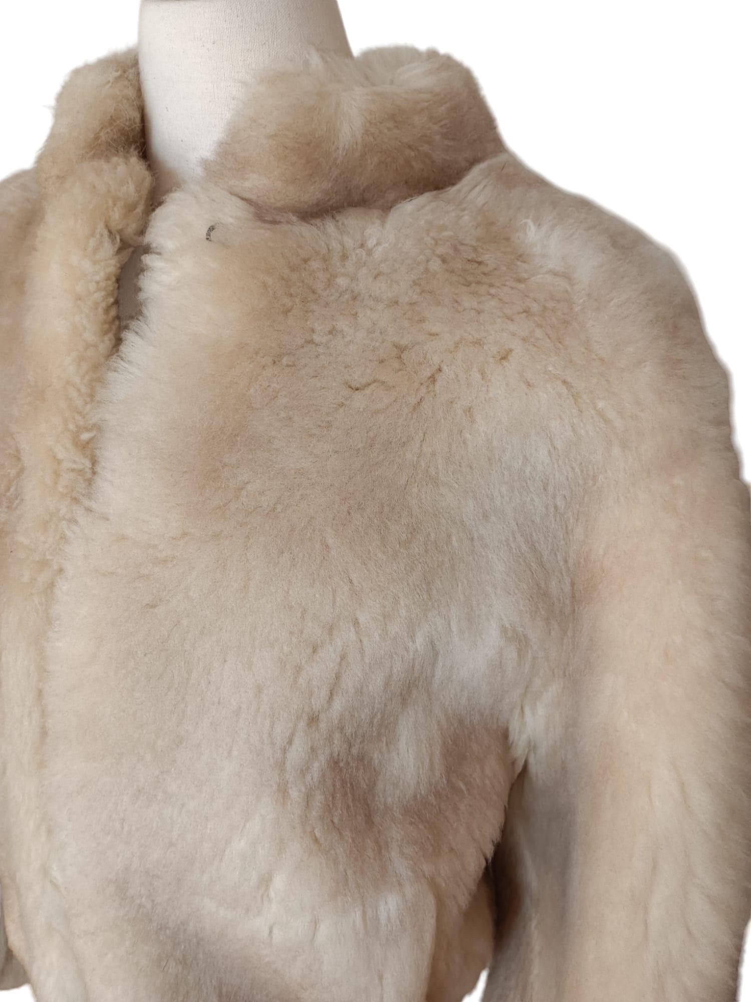 PRODUCT DESCRIPTION:

Shearling Fur Coat in a beautiful beige cream color

Condition: vintage 

Closure: Leather buttons

Color: Beige

Material: Shearling

Garment type: Shearling coat

Sleeves: Dolman sleeves with shirred cuffs

Pockets: Two front