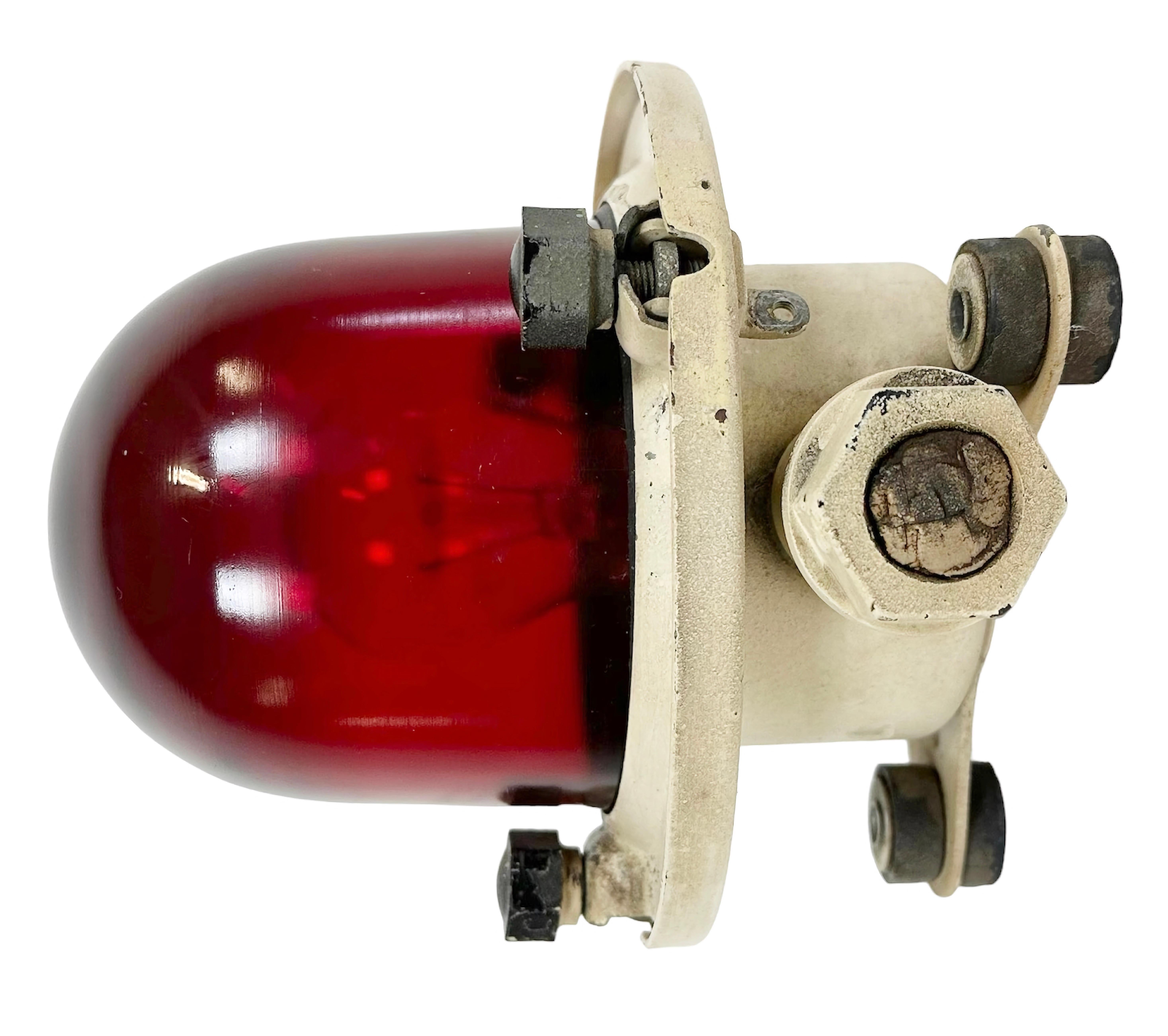 Vintage industrial celing or wall light made in former Soviet Union during the 1960s. It features a beige metal body and a red glass cover. The socket requires E 27/ E 26 light bulbs. New wire. The diameter of the lamp is 17cm. The weight of the