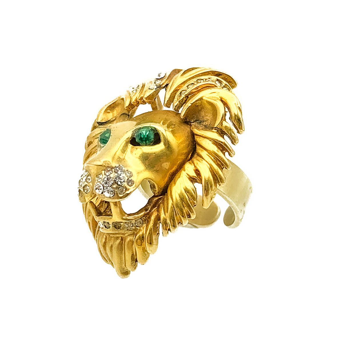 An arresting Vintage Lion Ring dating to the 1980s. Featuring the roaring face of a male lion; his wild mane fantastically rendered in the halo of gold with crystal chatons. His emerald crystal eyes artfully set and the gaping maw embellished by a