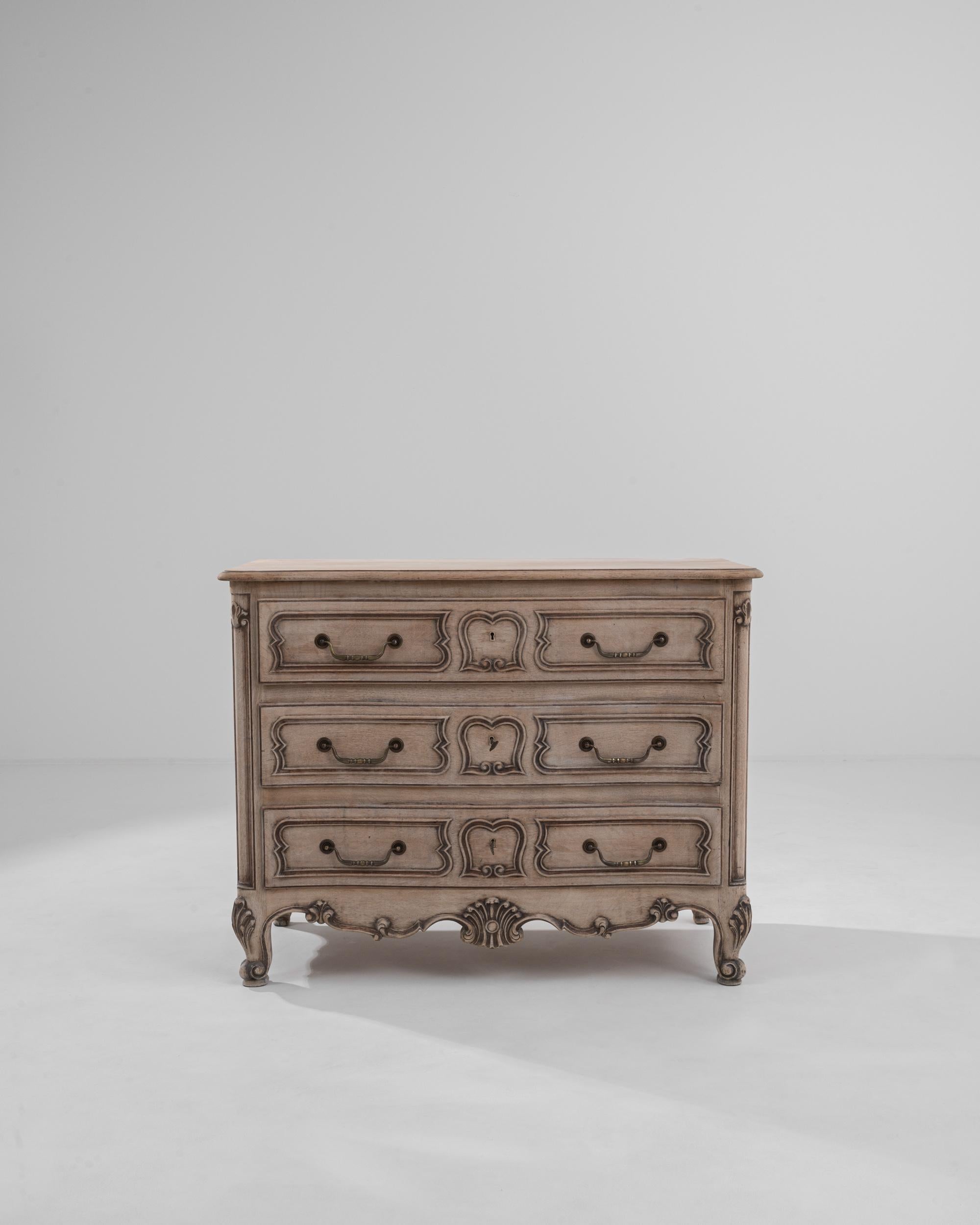 A chest of drawers made in Belgium, circa 1960. This bright and cheerful chest of drawers exudes both a robust regality and an approachable friendly aura. The swooping contours of its drawer handles interact playfully with the unique shaping of the