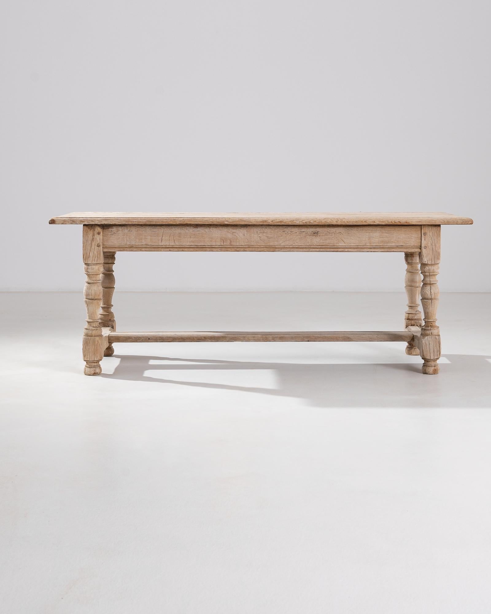 A belgian bleached oak coffee table from the 20th century. Lathed legs, wooden pins, and hand-carved edge details all speak to the high sense of craft that makes this unique table possible. A dialogue between past and present, the rich wood grain