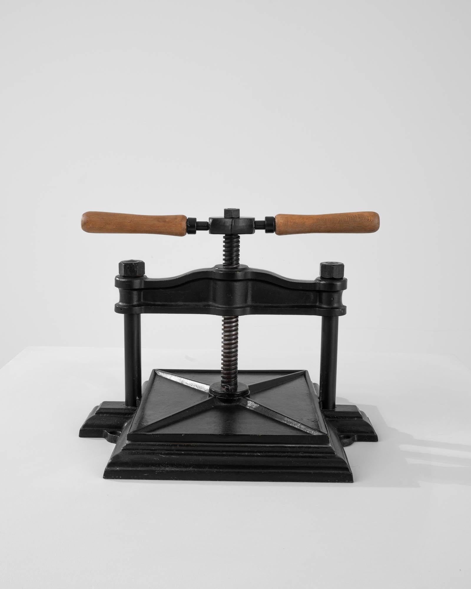 A cast iron press from 20th Century Belgium. Originally purposed as a book-binding press used in such places as banks or libraries, this unique antiquity suggests a niche function, while providing a universal visual appeal. This press features a
