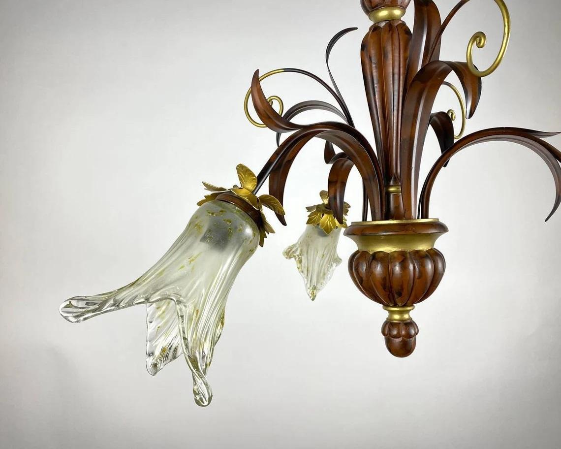 Beautifully carved metal chandelier in brown color with three arms, each with a wonderfully shaped glass lampshade.

Belgium, 1970s.

The Ceiling Lamp in Floristry Design with gilt decor.

The laconic design of the chandelier will become a