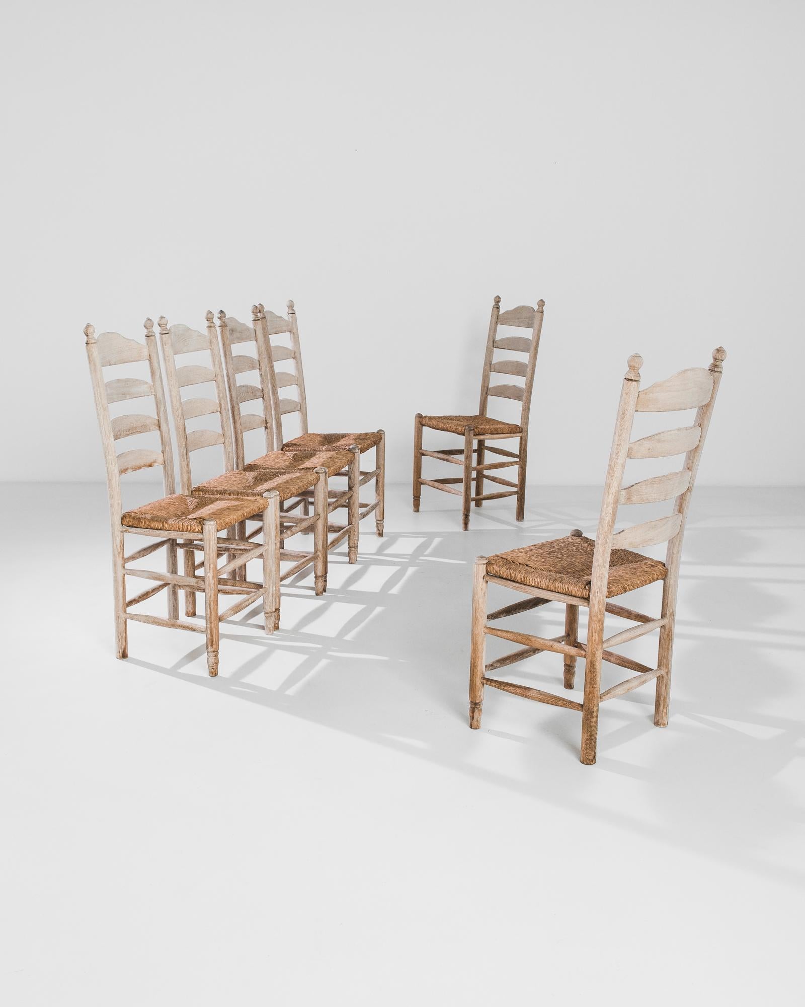 Simple but elegant, this set of dining chairs made in Belgium circa 1970 exudes the air of a cosy farmhouse. Excellent ladderbacks give the chairs an expressive silhouette, accentuated by singular detail – charming finials on the top. 

Another