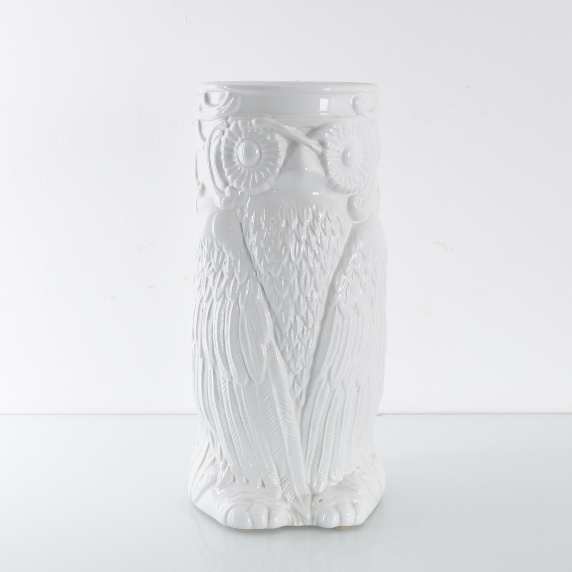 A ceramic vase produced in Belgium, circa 1960. A white 45cm ceramic in the shape of an owl standing alert, wing-wrapped. Fine detail in the relief etching out every feather. Much like wisdom itself, this understated piece emanates a cool