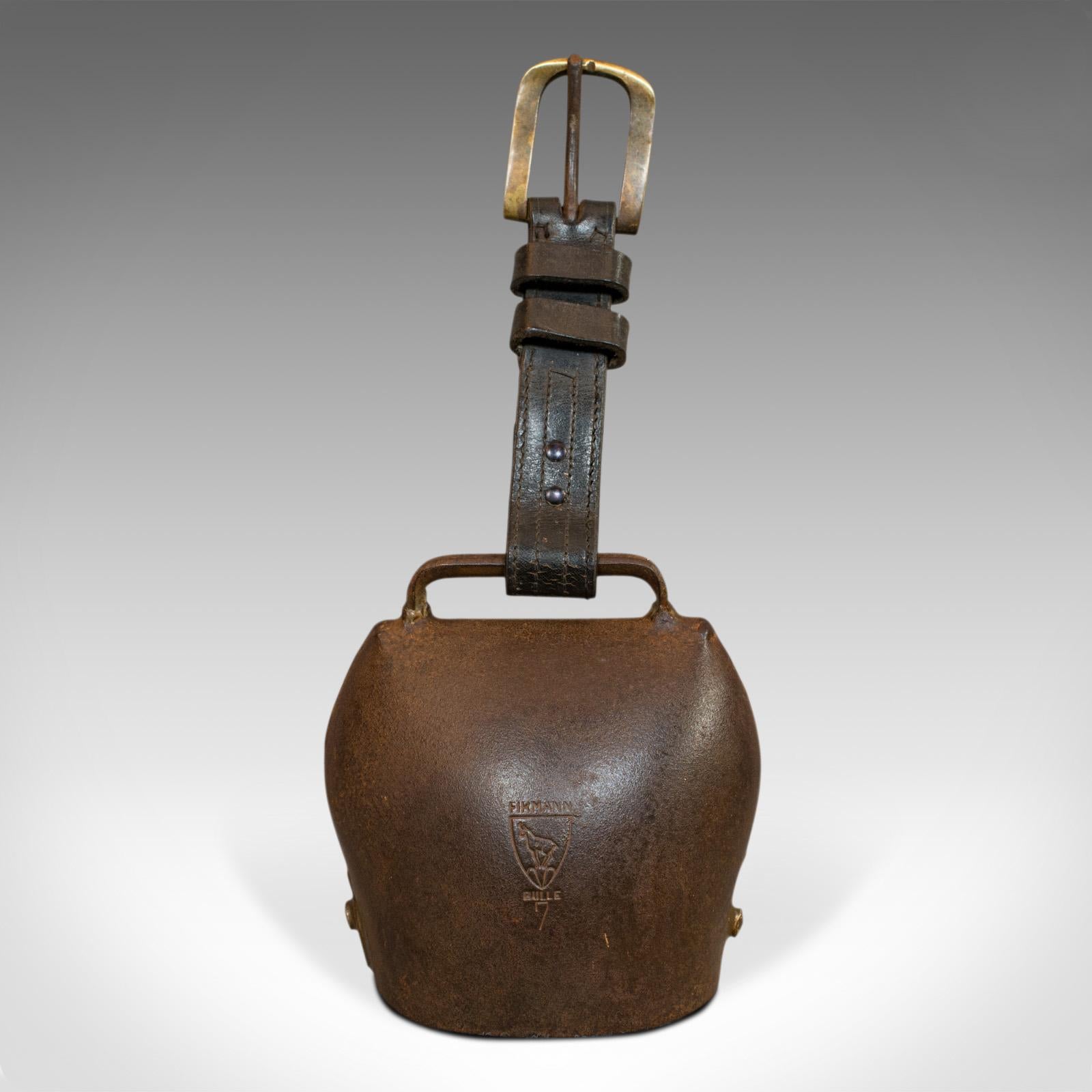 This is a vintage bell. A Swiss, tin and leather 'Grade 7' trychel cow bell or cloche by Ateliers Firmann, dating to circa 1950.

Classic Alpine cloche
Displays a desirable aged patina - weathered tin in dark russet hues
Rings with an evocative,