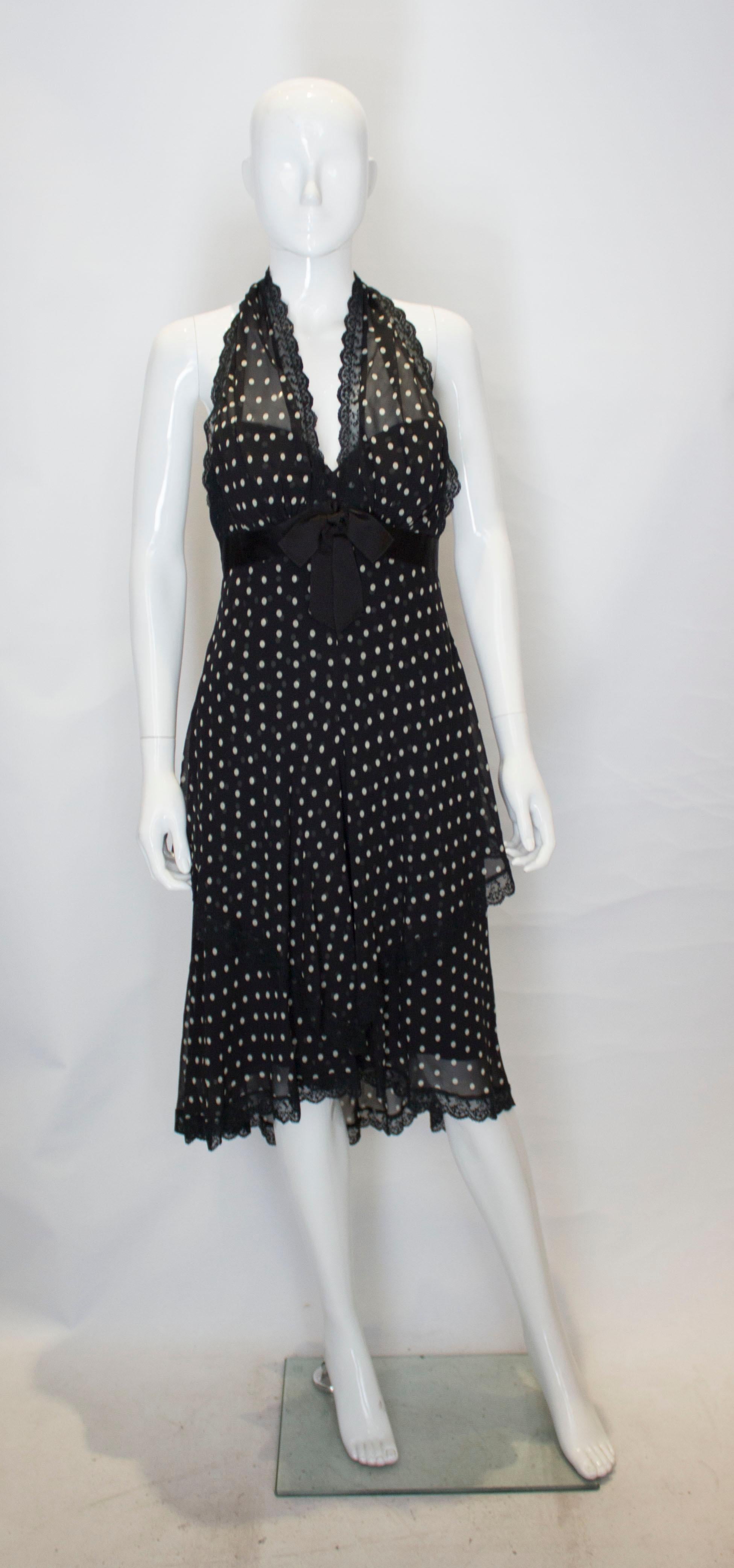 A pretty and chic  vintage silk dress by Bellville Sassoon,Lorcan Mullany. The dress is silk lined and has self fabric buttons , and a halter neck with lace trim .There is a bow detail at the front.