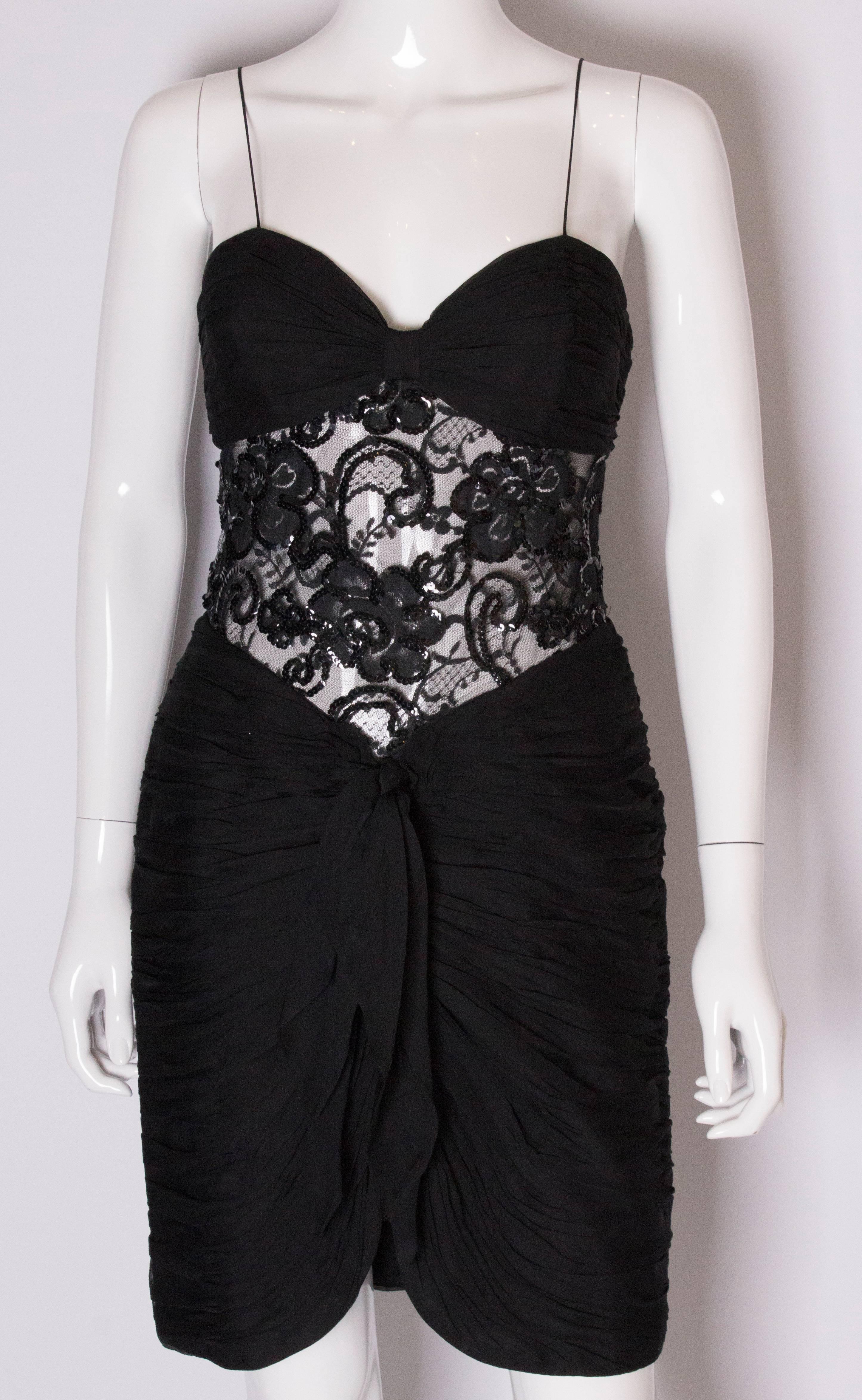 A chic cocktail dress by British designer Bellville Sassoon. In a black silk chiffon with lace panels, front and back the dress is a real head turner. The dress has a central back zip and spagetti straps.