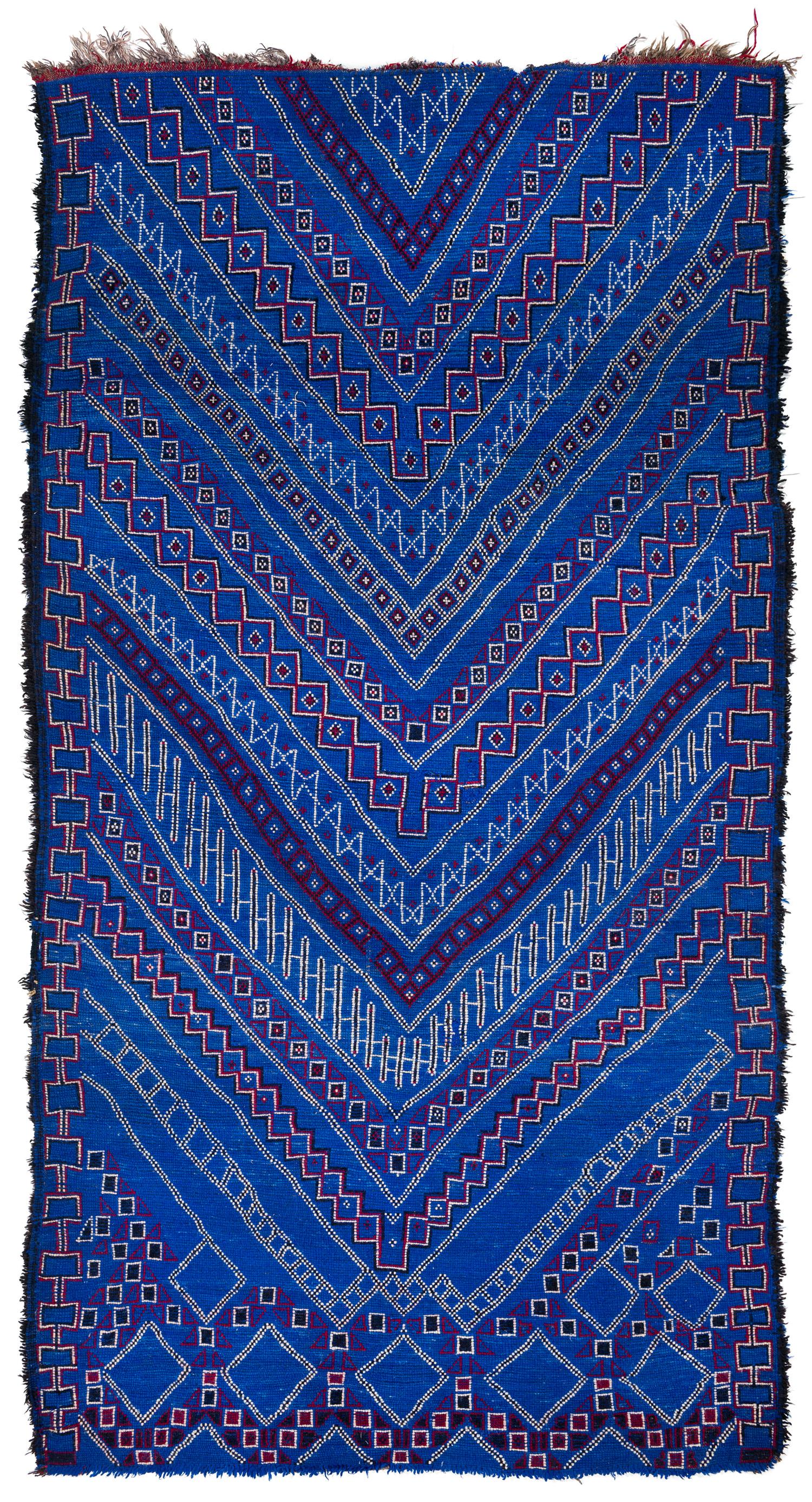 This rare authentic antique Moroccan rug came from the Beni Mguild tribe from the central middle Atlas mountains from the region of the Guigou valley. This rug features beautiful blue dye, exhibiting rich color glowing color with red and white