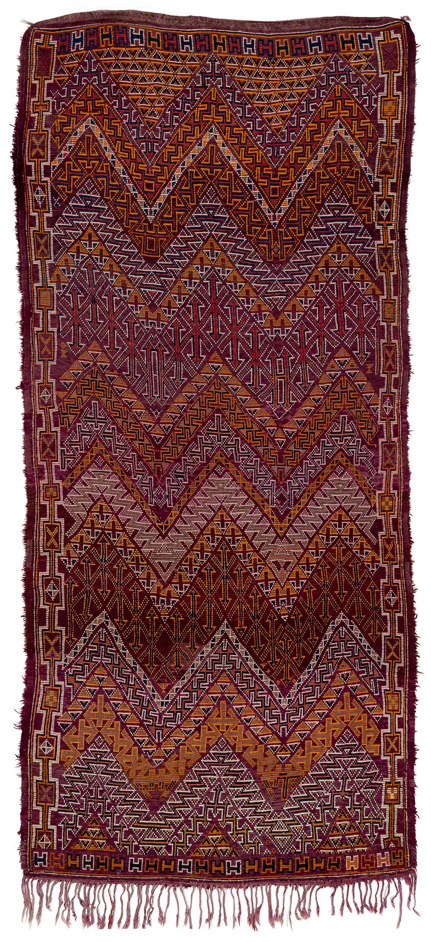 This vintage Moroccan rug is in perfect condition with a very dense structure. It is a monumental rug and was certainly made and used as a prestige carpet for special occasions only. Woven in deep maroon wool with pops of orange and blue