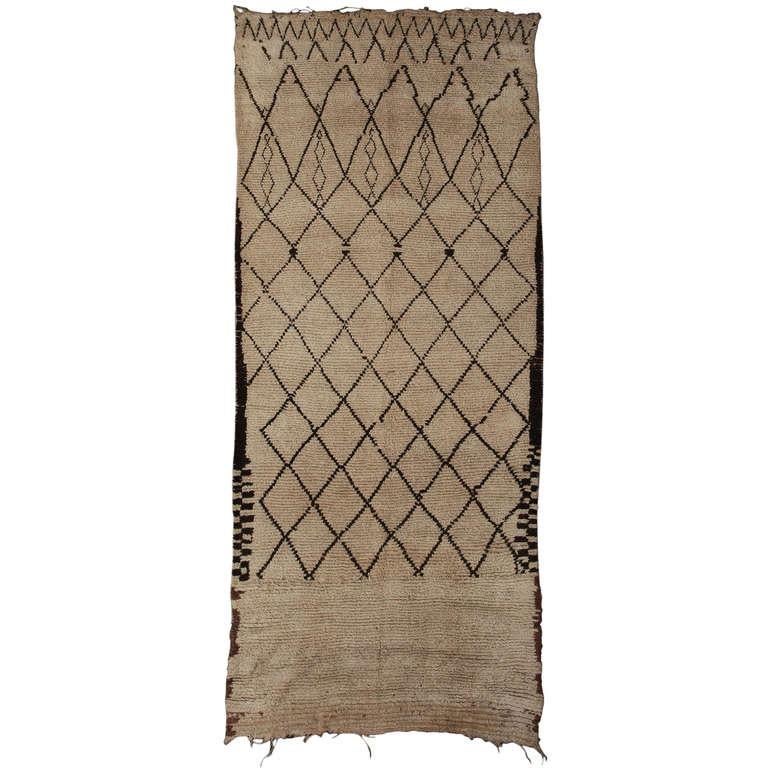 Dieser Beni Ourain-Teppich wurde in den 1920er Jahren von den nomadischen Berberstämmen in Nordafrika hergestellt. Die Beni Ourain-Teppiche zeichnen sich durch ihre geometrischen Linien aus, die ein asymmetrisches Gesamtmuster bilden. Dieser Teppich