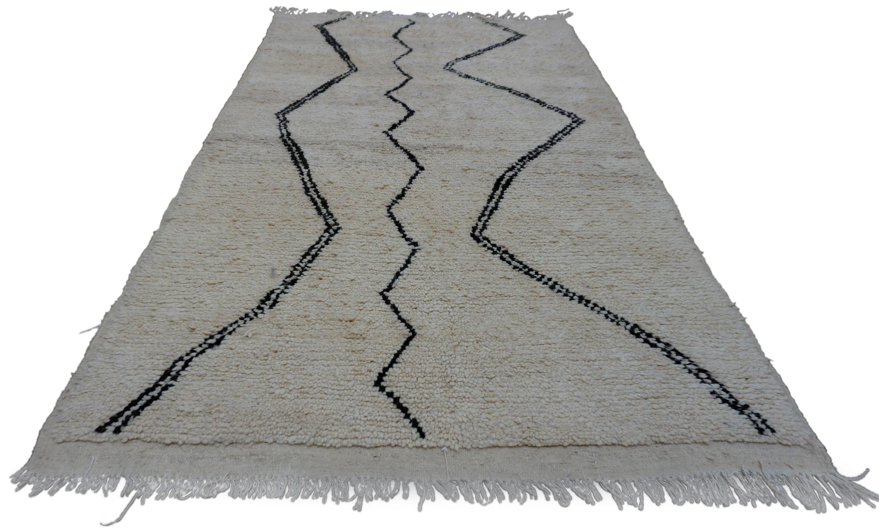 Dieser handgeknüpfte Wollteppich ist eine klassische Darstellung der Beni Ourain Webtradition, die durch minimalistisches Design und luxuriöse Textur zum Leben erweckt wird. Der von Berberhandwerkern handgefertigte Teppich zeigt ein natürliches
