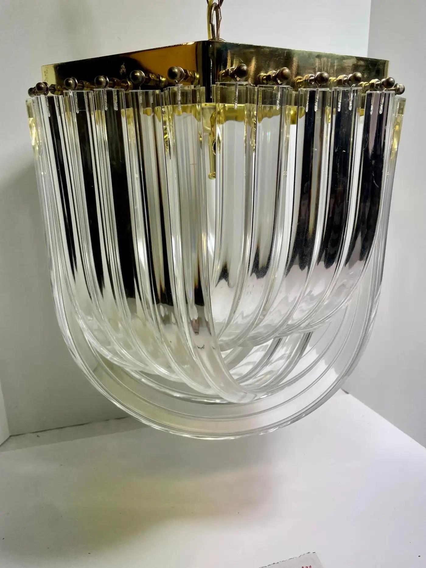 Six sided Lucite and Brass Ribbon Chandelier, Eight sockets with candelabra.  Includes  chain and ceiling canopy. 14