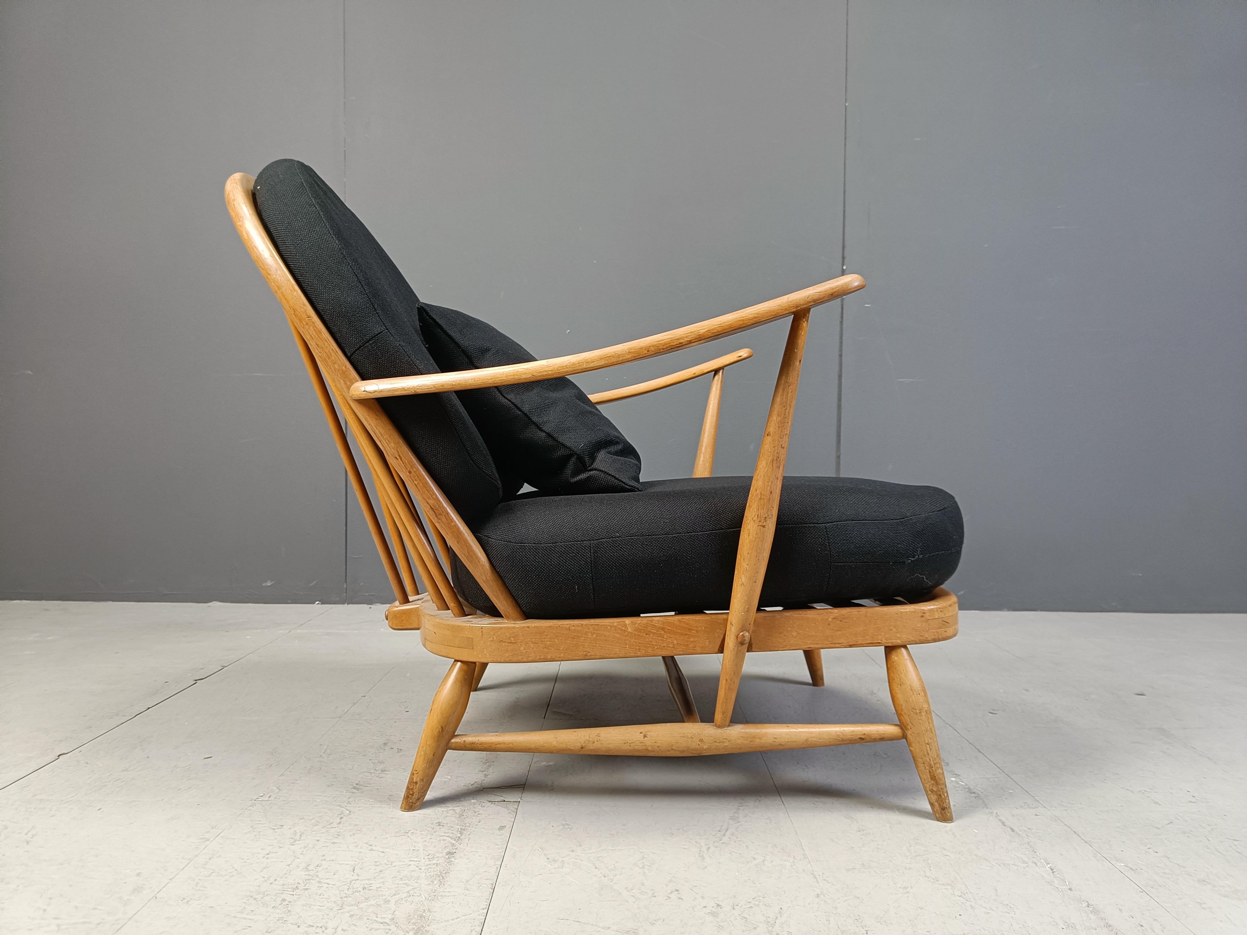 Elegant vintage bentwood armchair with footstool by Ercol, made in UK in the 1960s.

It has a nicely crafted wooden frame, with a spindle back and curvy armrests.

Completely upholstered with new black fabric, to start its new life.

Nice rustic