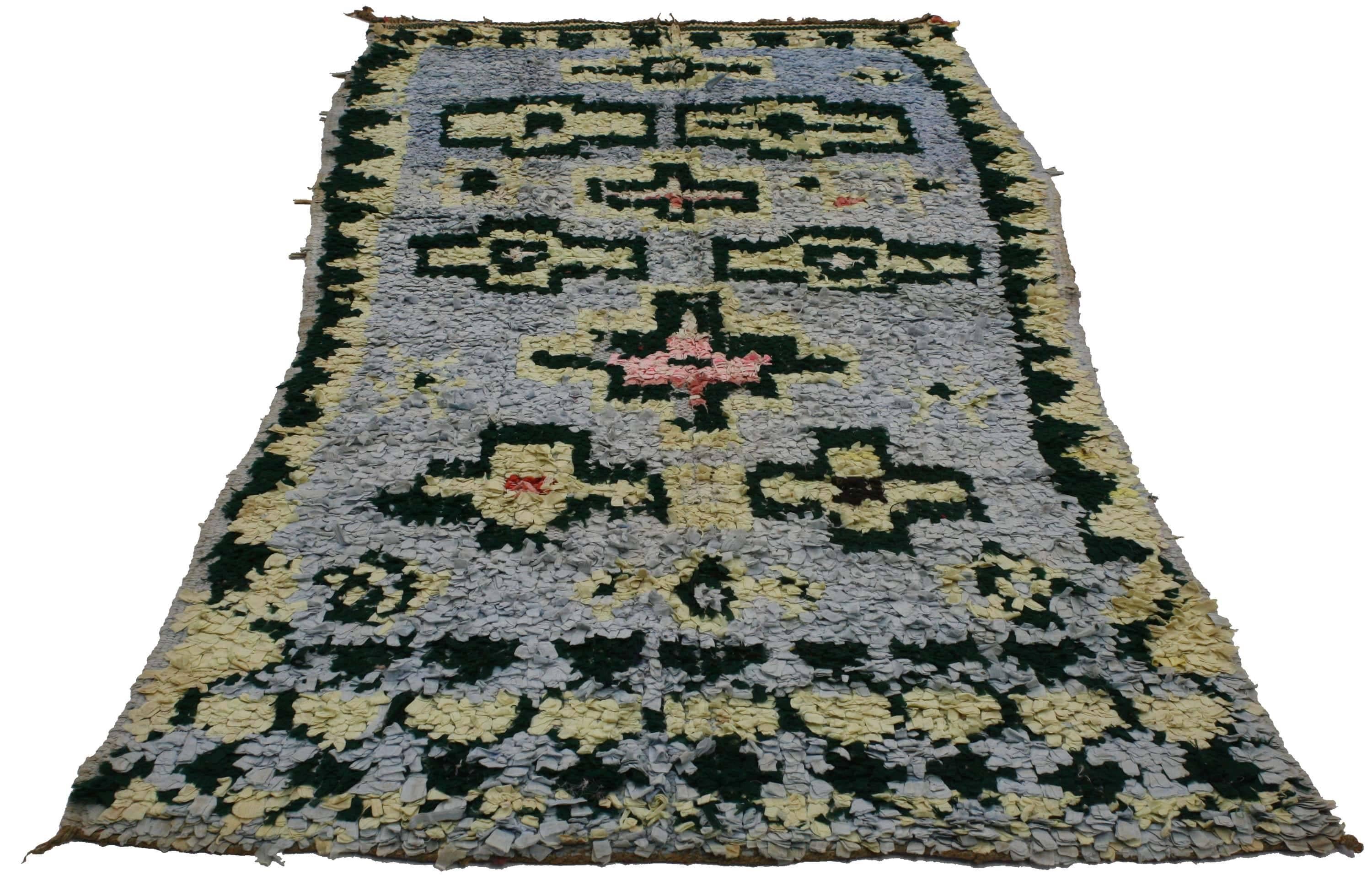 20318 vintage Berber Moroccan Boucherouite rug. The subtlety of a light blue background allows the bold colors used to ornament the rug to stand out. The rug is primarily ornamented by large cruciform shapes, Solomon Star fertility motifs, a flurry
