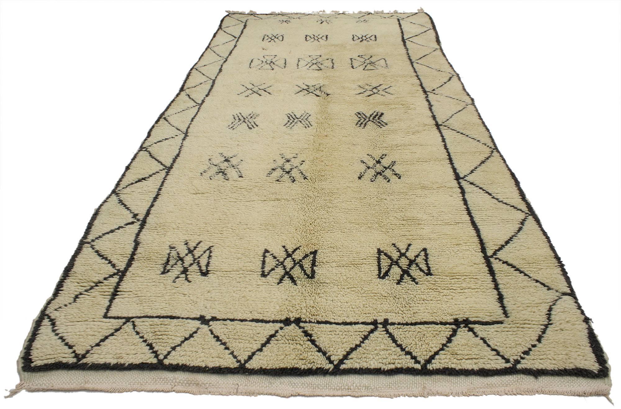 20572, vintage Berber Moroccan rug. The creamy-beige provides a beautiful backdrop for the black coffee colored design featured on this vintage Berber Moroccan rug. This Moroccan rug is rich in Ancient Berber culture, as the design displays a host
