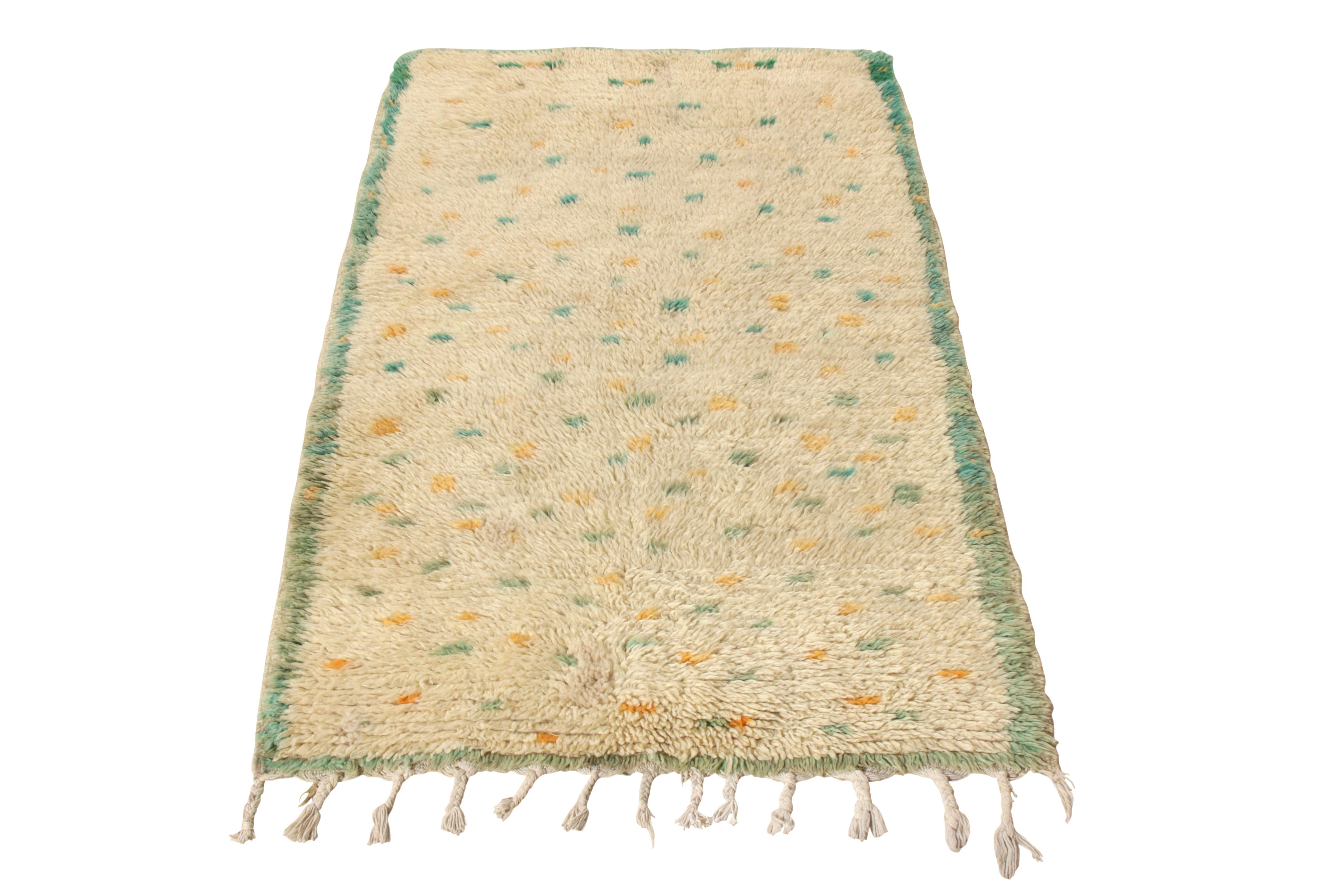 Hand knotted in Boucherouite wool, a vintage 3 x 5 Berber rug originating circa 1950-1960 joining Rug & Kilim’s Moroccan Collection. Prevailing in gorgeous tones of green and yellow against a creamy beige, this shag high pile witnesses a
