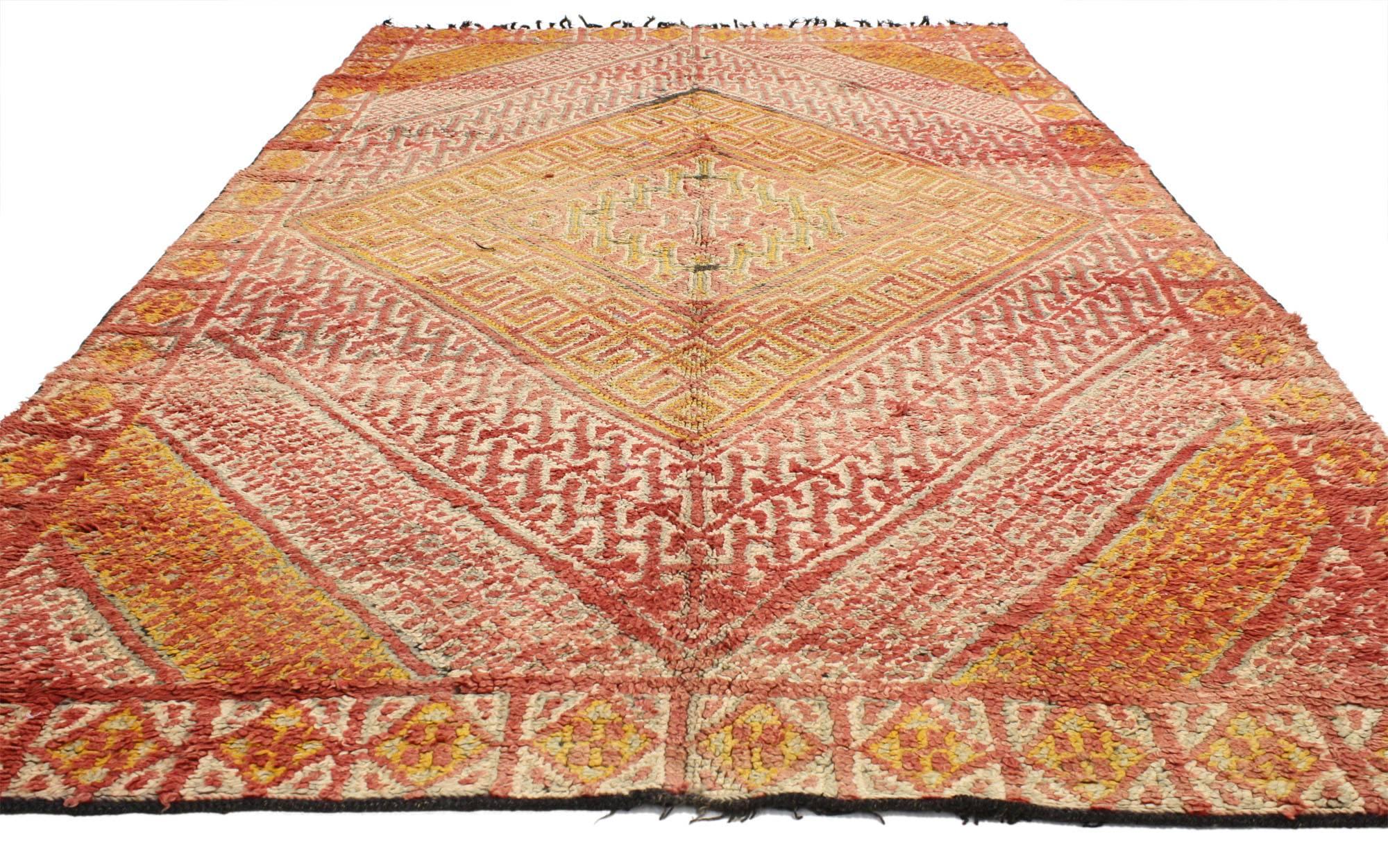 20610 vintage Berber Moroccan rug with tribal style. Subdued hues of fiery red and glowing orange awaken the senses while evoking images of a warm Moroccan sunrise. Intricate geometric patterns house themselves within the larger arrangement of