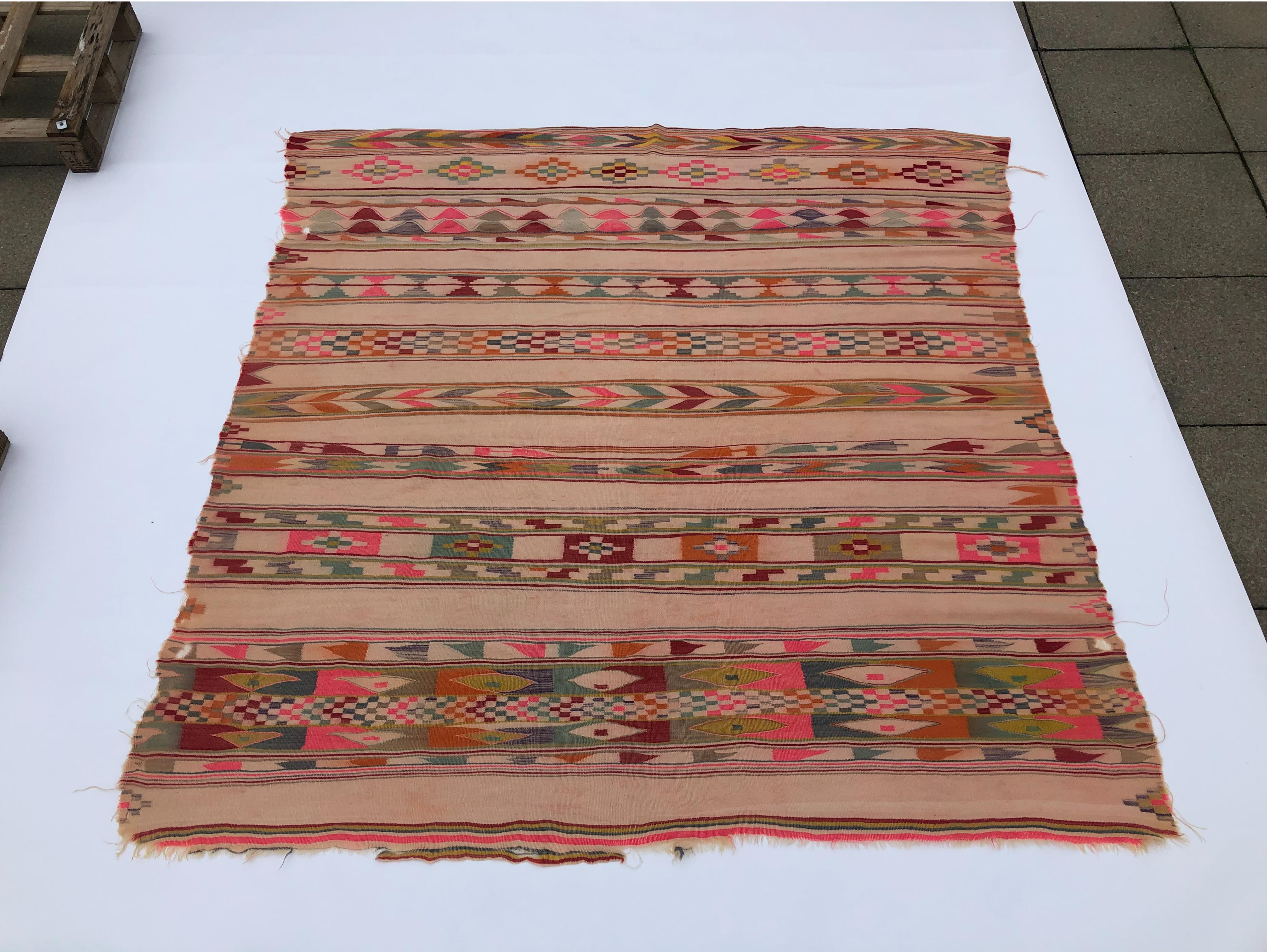 Discover a piece of history with this vintage Berber rug from 1930s Algeria, showcasing tribal geometrical patterns in groups of parallel lines.

The rug's dominant neon pink, burnt orange, brick red, and various green shades create a vibrant and