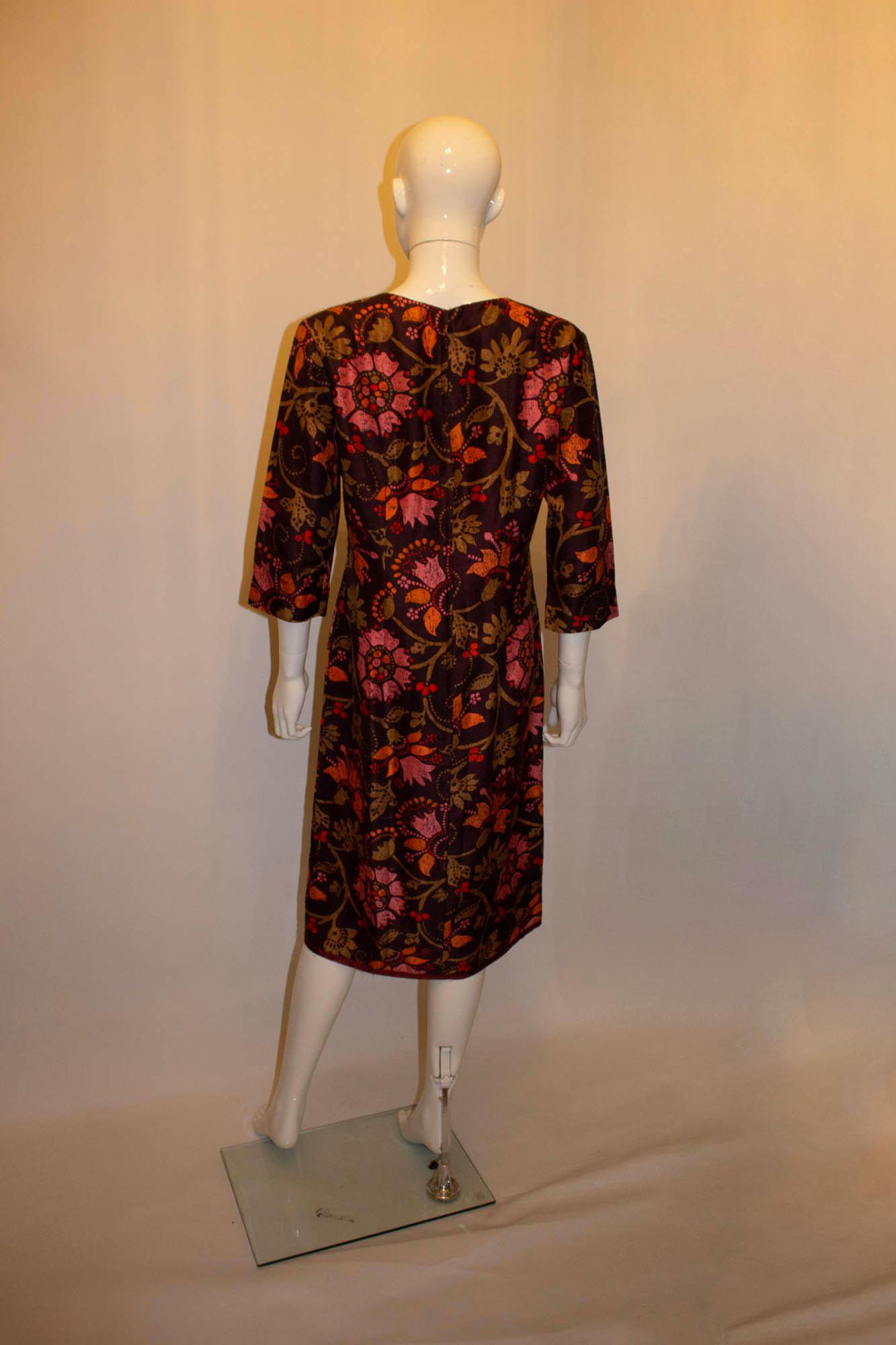 A wonderful silk dress by Bermard Freres ( Paris, London)  in a Liberty print. The dress has a brown background, with a pink and orange design. It has a round neckline, elbow length sleaves and is fully lined. Measurements: Bust up to 40'', length