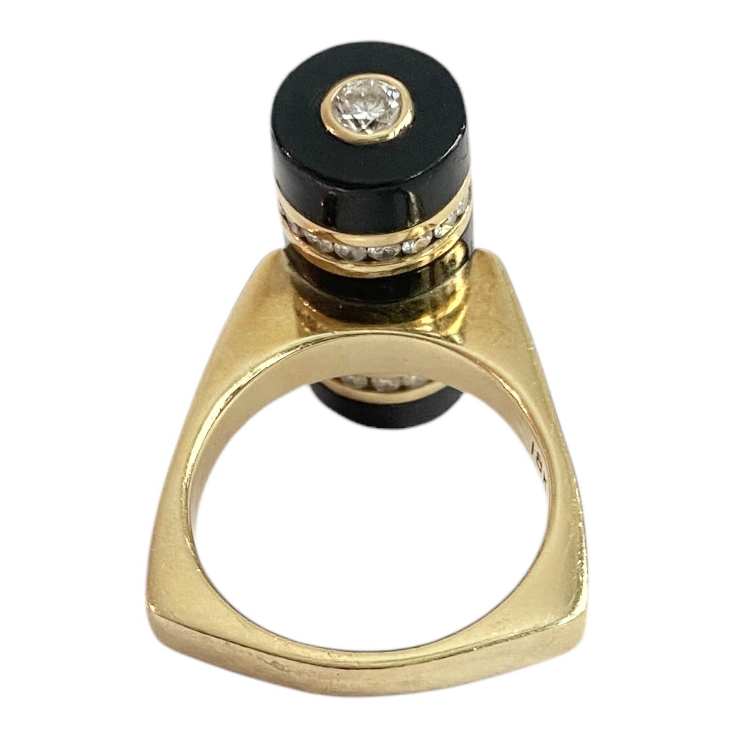 Vintage Bernard K Passman ring crafted in 18k yellow gold, featuring a bold cylindrical design. The black coral is decorated by two rows of channel set brilliant-cut white diamonds and an inserted bezel set diamond solitaire on each end. The ring's