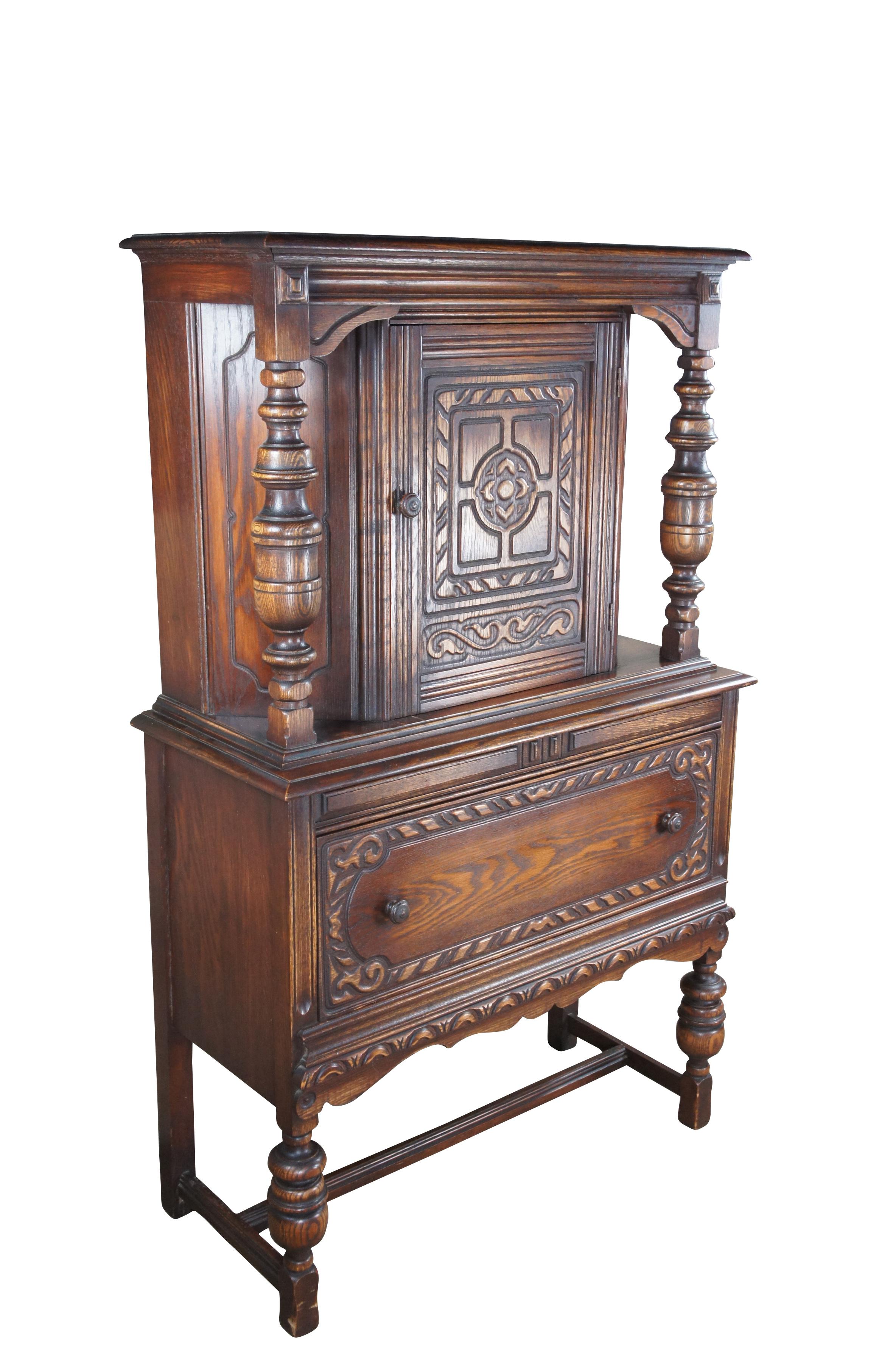 Vintage Jacobean style china hutch by Bernhardt Furniture, circa 1930-40s.  The cabinet was designed to resemble a court cupboard.  Features an upper hutch with one shelf flanked by baluster turned columns over a large lower dovetailed drawer for