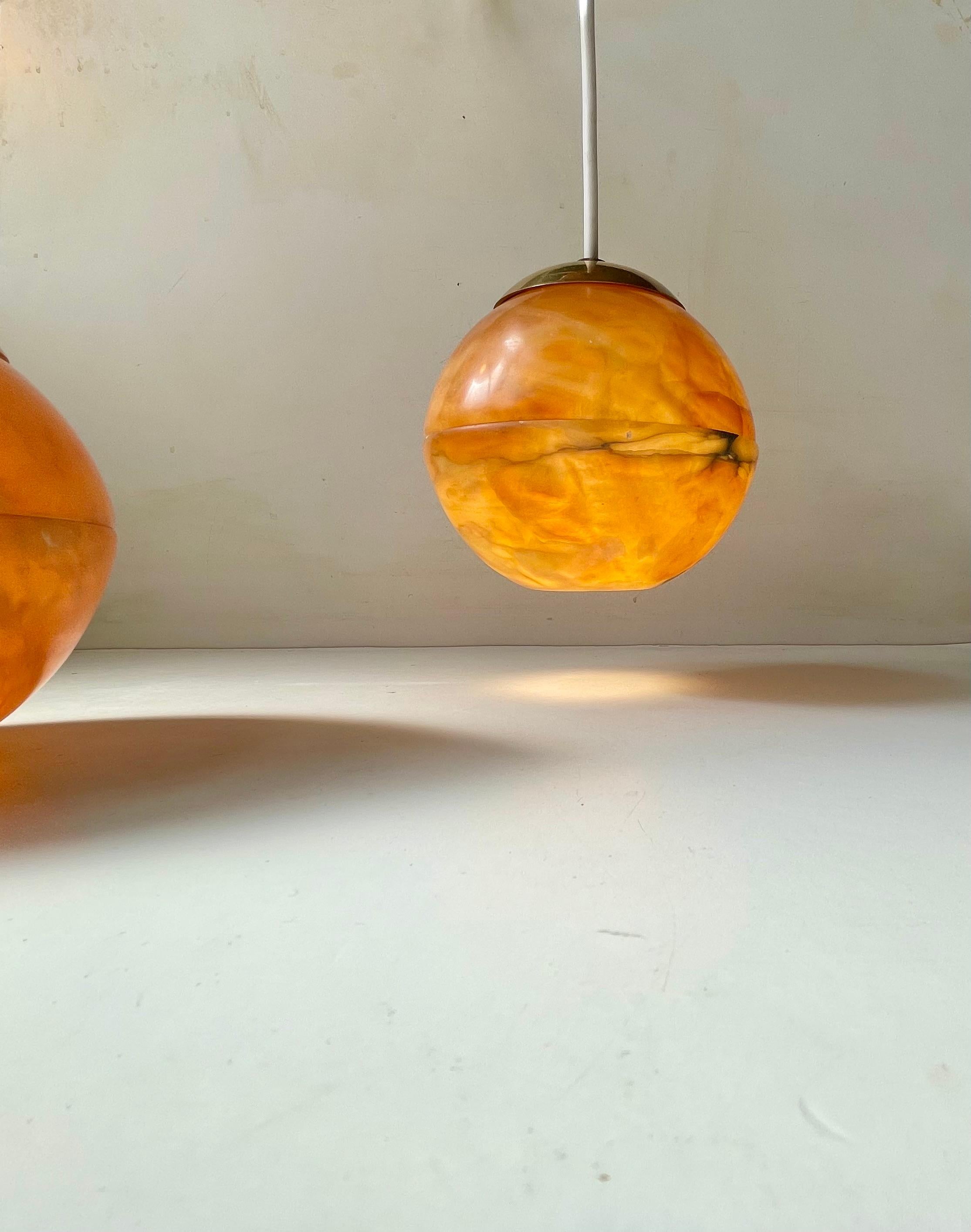Why should ceiling lights not mimic the shape and color of the evening sun. Well this Italian, possibly bespoke, set does indeed. They feature shades made from translucent alabaster stone set as globes beneath brass tops (slightly diffrent heights).