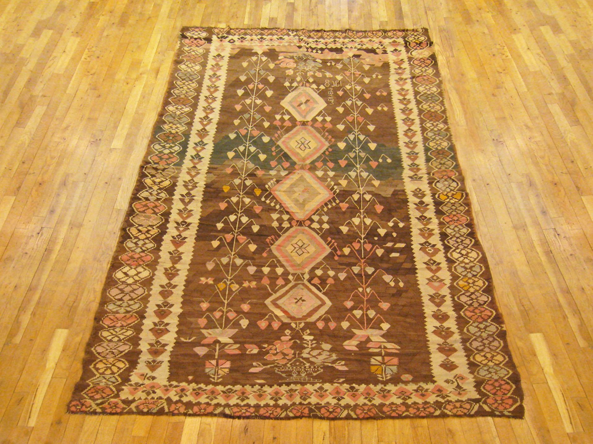 A vintage Bessarabian Kilim oriental rug in kaleghi (gallery) size, size 11'3 x 5'6, circa 1930. This handsome handmade flat-woven carpet has no upward pile, and features a series of diamond designs at center, flanked by stylized tree motifs in the