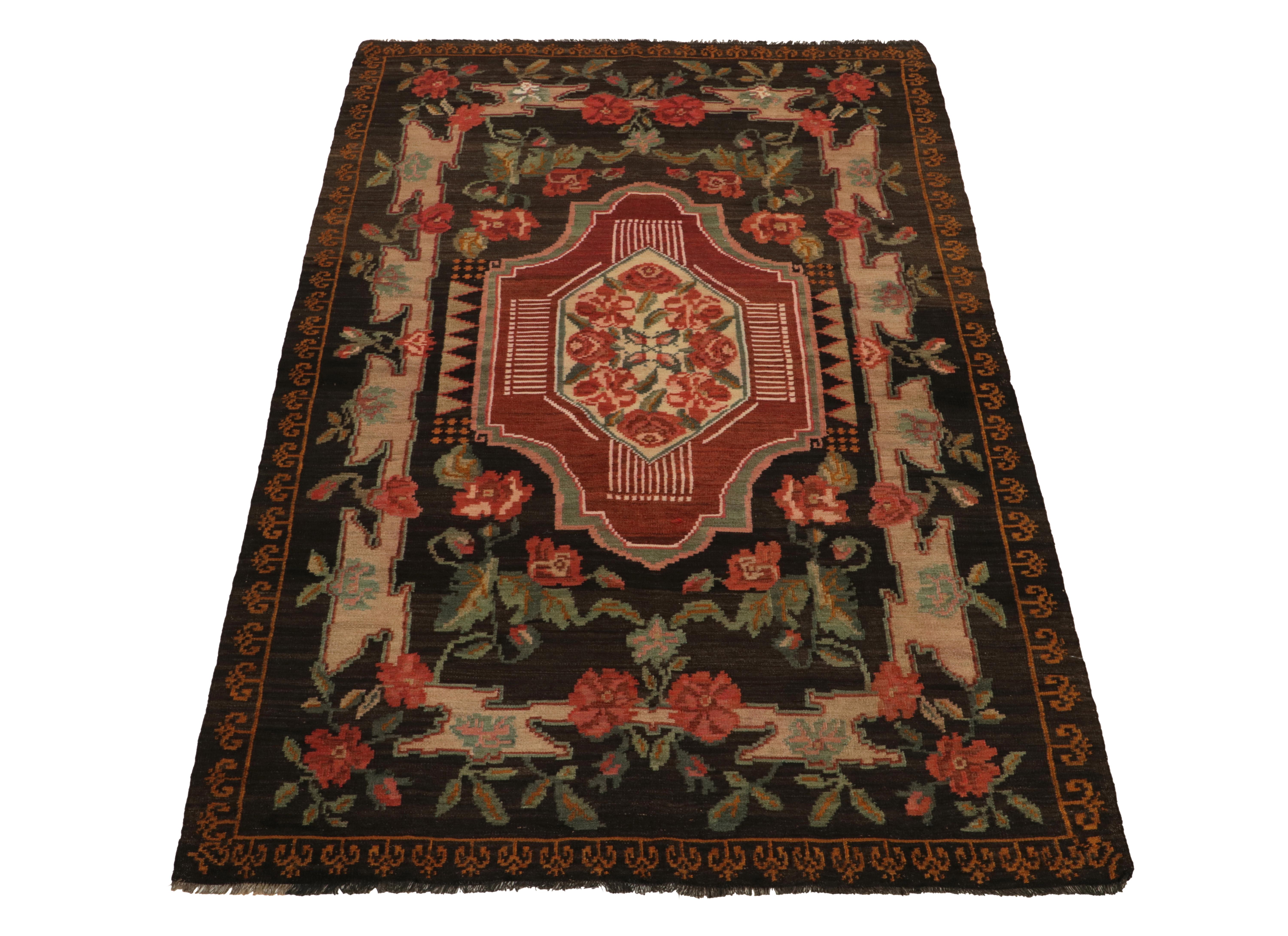 Handwoven in wool, a vintage Bessarabian kilim rug from our flatweave selections. Originating from Turkey circa 1950-1960, the creation carries an unusual European allure with rich red, brown & green florals flourishing on the deep frame for an