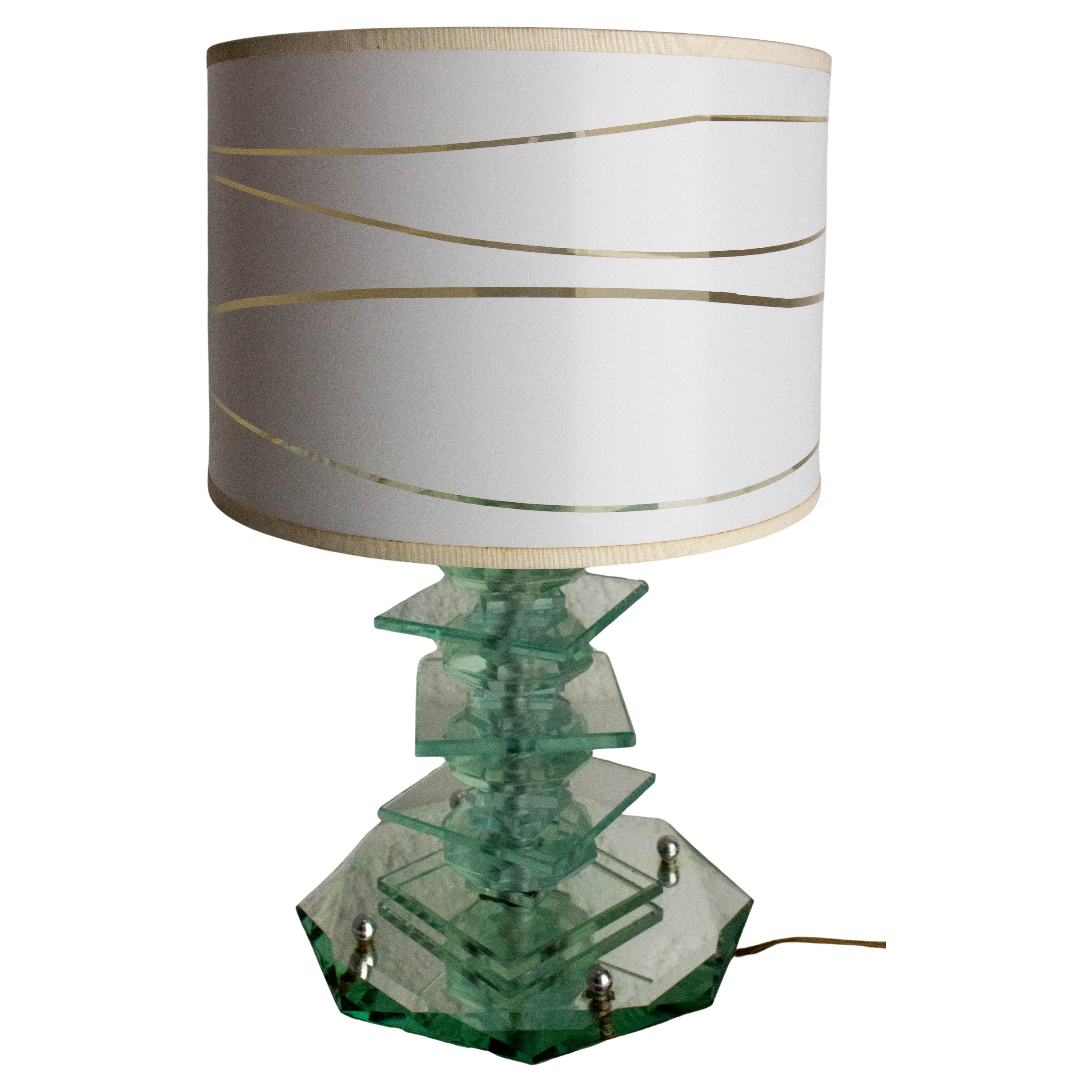 Pequeña lámpara de mesa típica de los años de la vendimia hacia 1960
El diseño de la lámpara, todo espejos biselados y cristal tallado, la convierte en un objeto especialmente luminoso. La base está sostenida por cuatro bolas de cristal y