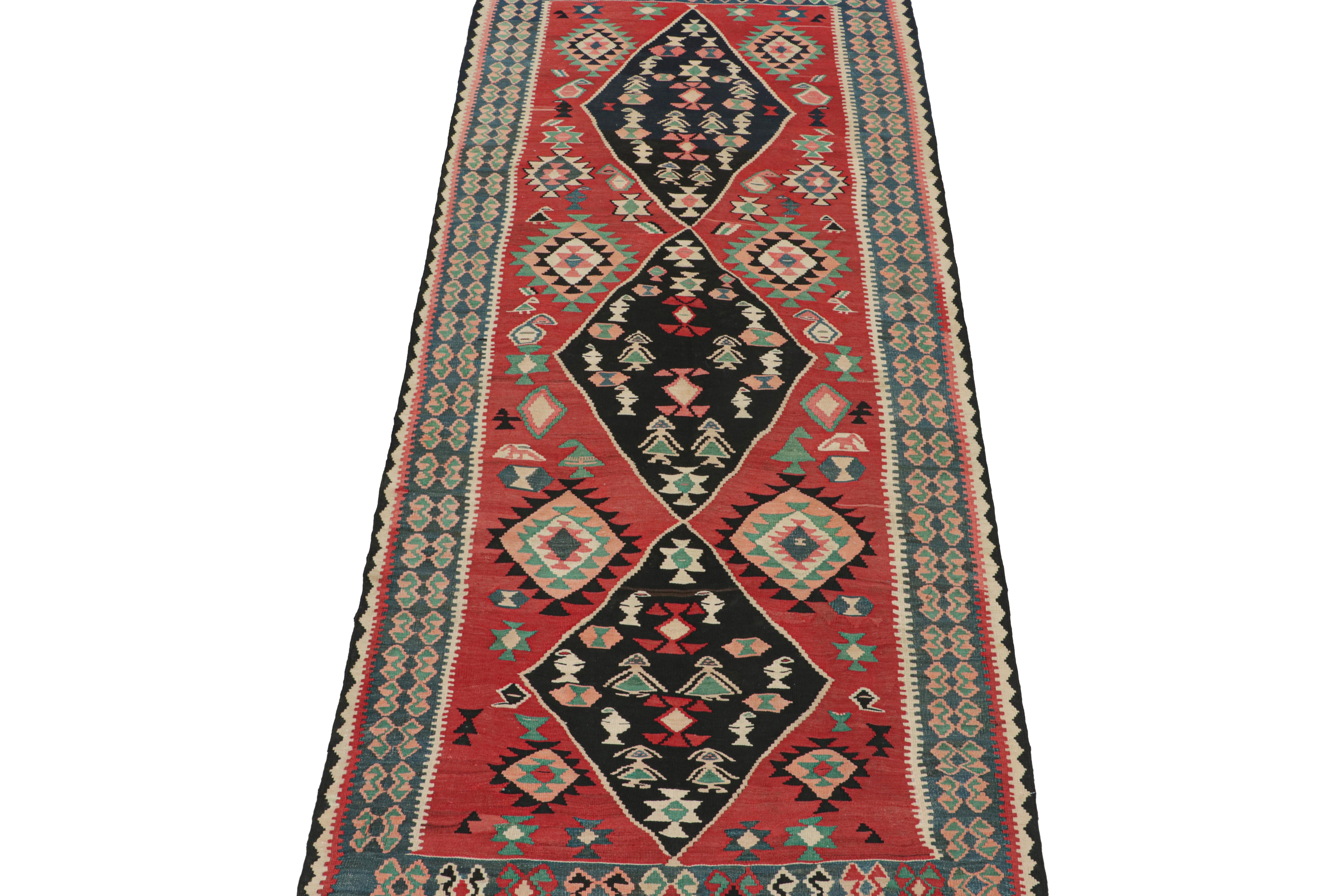 Dieser persische Vintage-Kilim 5x12 ist ein Galerie-Läufer, der vermutlich ein Bidjar-Teppich ist, der um 1950-1960 in Wolle gewebt wurde.

Das Design besteht aus schwarzen Rautenmedaillons auf einem leuchtend roten, offenen Feld, die beide mit
