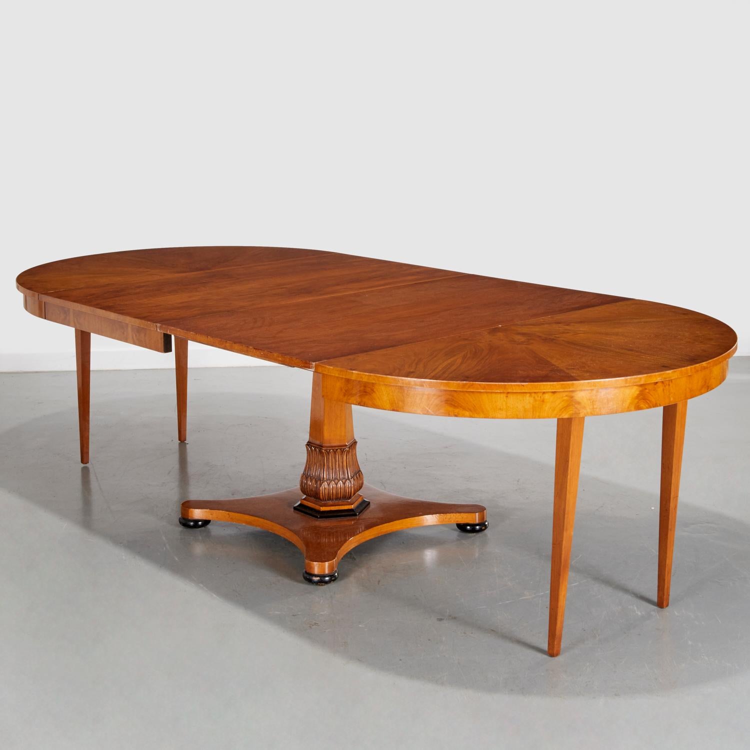 20. Jh., amerikanisch, ein wunderschön gearbeiteter runder Esstisch im Biedermeier-Stil aus gemasertem Nussbaum mit paket-ebonisierten Akzenten. Der exquisite Sockel des Tisches, der aufwändig in Form eines Vierpasses geschnitzt ist, ist ein