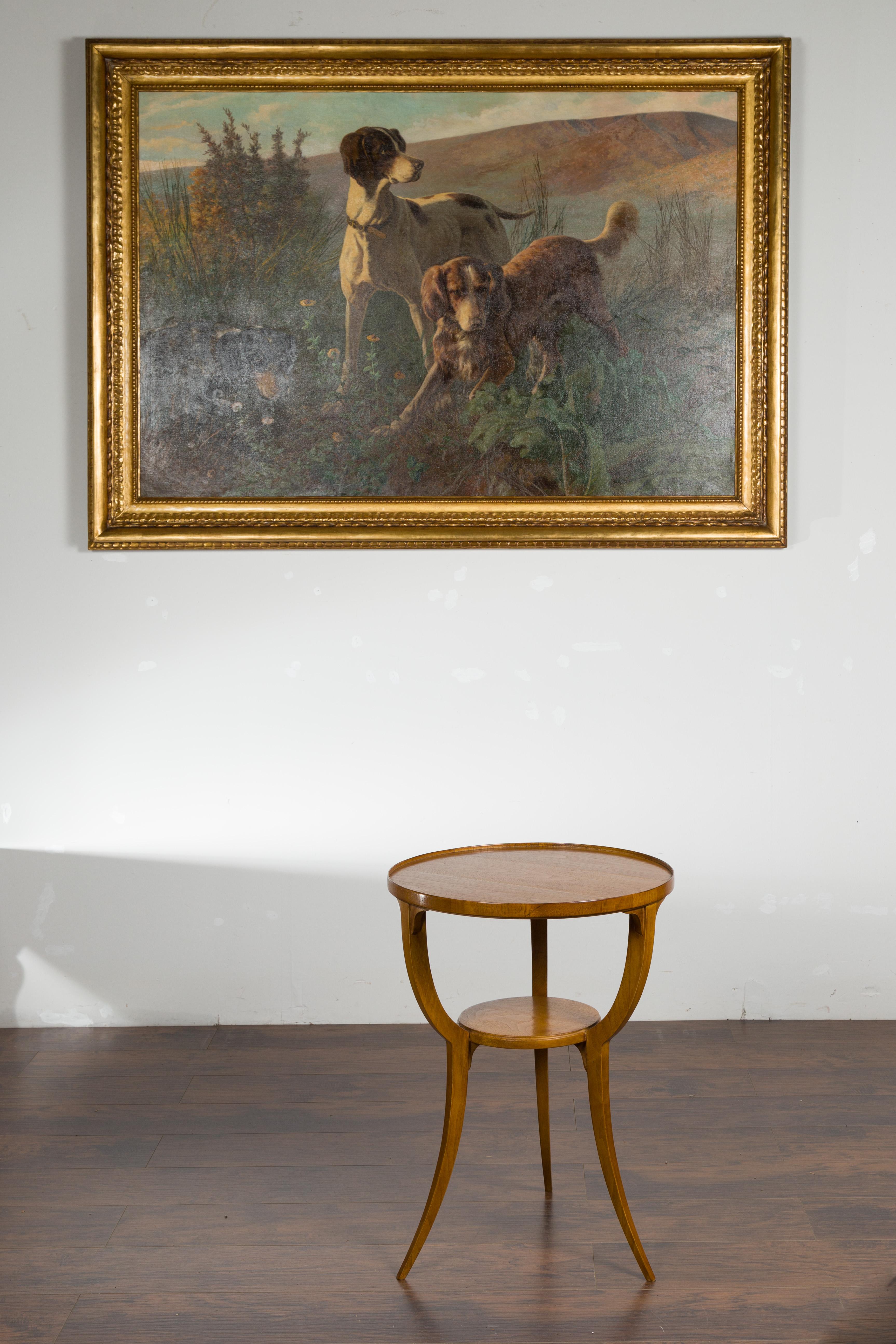An Austrian Biedermeier style walnut guéridon table from the mid 20th century, with tripod base and shelf. Created in Austria during the midcentury period, this Biedermeier guéridon table features a circular top with raised border, sitting above a