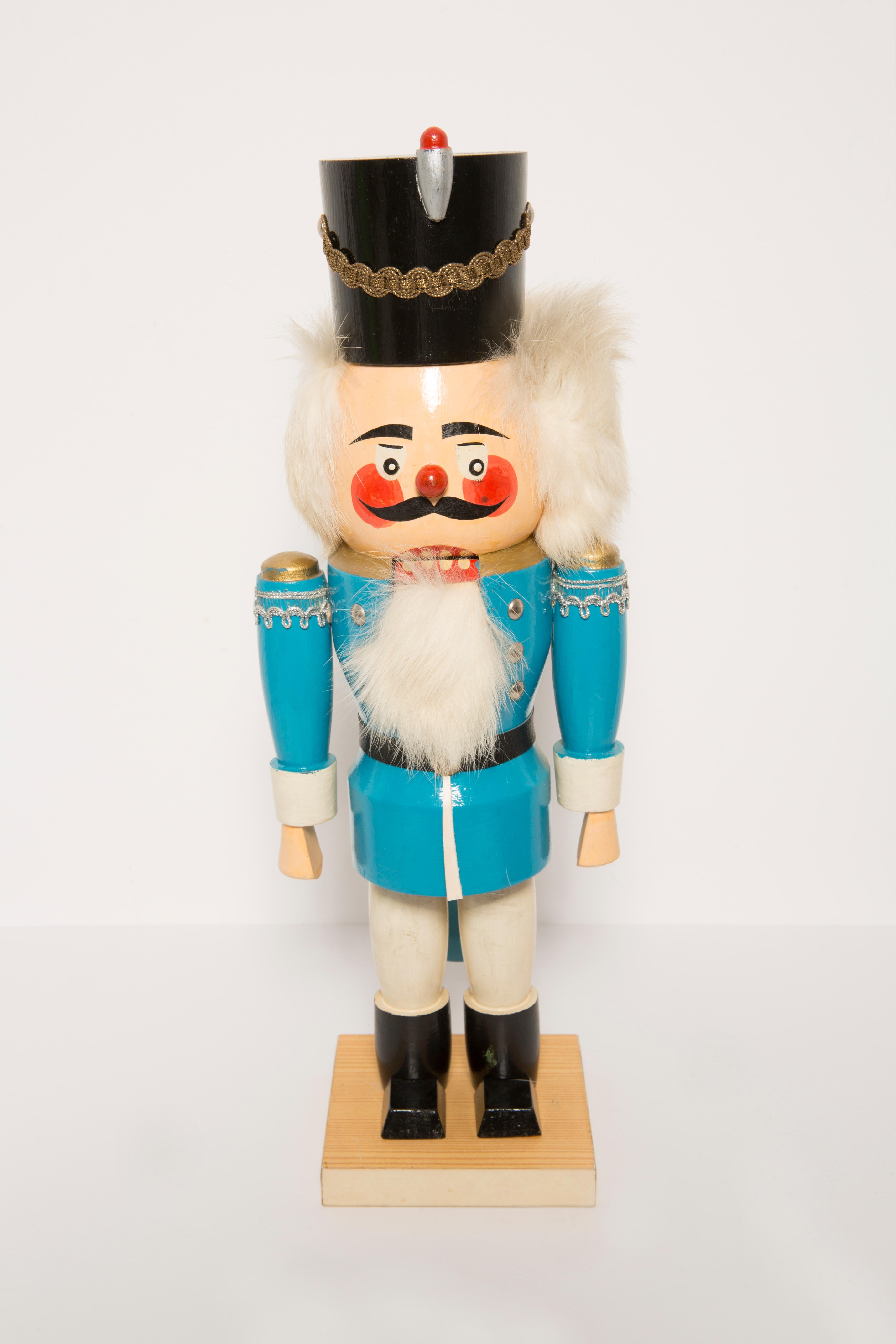 Big wooden nutcracker figure from the Erzgebirge. The region Erzgebirge formerly Eastern Germany is famous for this special kind of nutcrackers, where intricate carving has been their home. Completely hand-painted in bright colors and decorated with