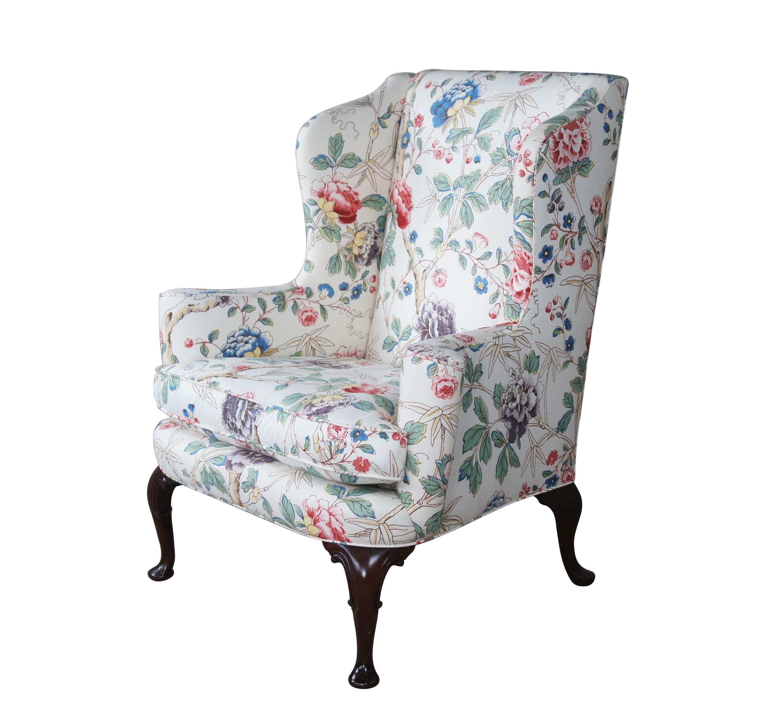 A beautiful Queen Anne style wing chair by Biggs Furniture, circa last half 20th century. Made from mahogany with a highback and scrolled and flared arms. The chair is supported by downswept cabriole legs leading to pad feet. The floral fabric is