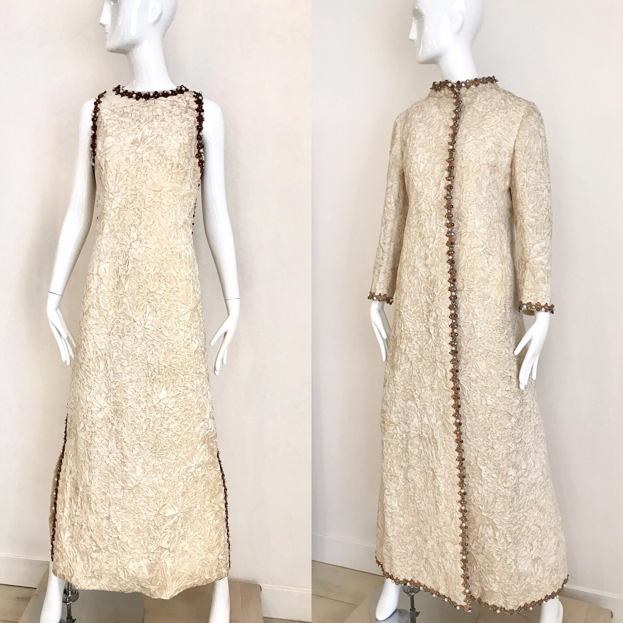 Timeless 1960s Vintage Bill Blass for Maurice Rentner creme crushed velvet sleeveless maxi dress embellished with faux pearls and rhinestones. Dress comes with matching evening maxi coat. 
Dress measurement: Bust: 36 inches/ Waist: 34 inches/ Hip: