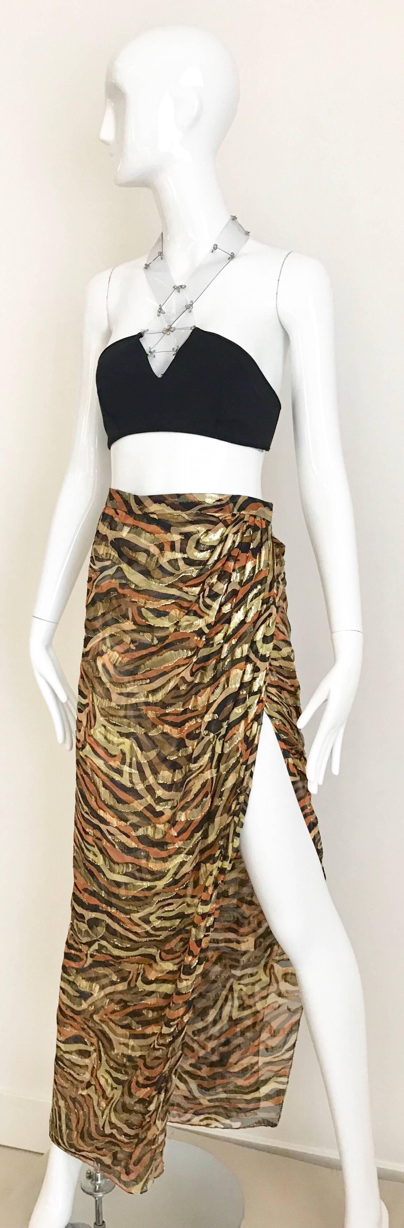 Sexy and fun 90s Bill Blass metallic silk lame zebra print in gold, black and orange.
Skirt is a wrap style. Skirt is styled with vintage Paco Rabanne 2 piece bathing suit available for purchase. 
Skirt fit size 0/2/4/
Waist is 26inches but hook an