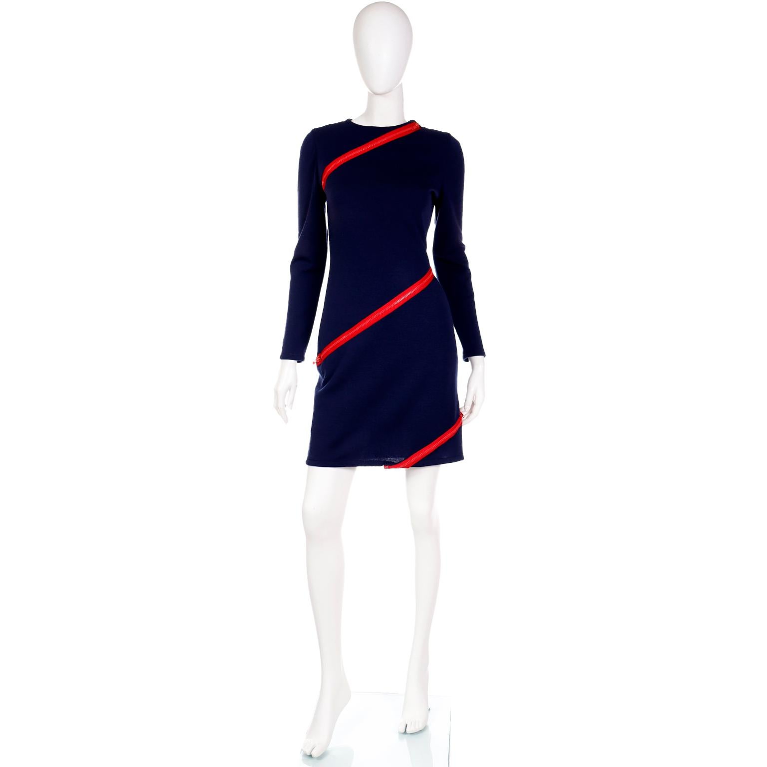 We are obsessed with this incredible vintage Bill Blass zipper dress! This fun dress is in a deep navy blue knit and it features contrasting red zippers sewn diagonally across the dress! The zippers are functional and can be worn partially unzipped