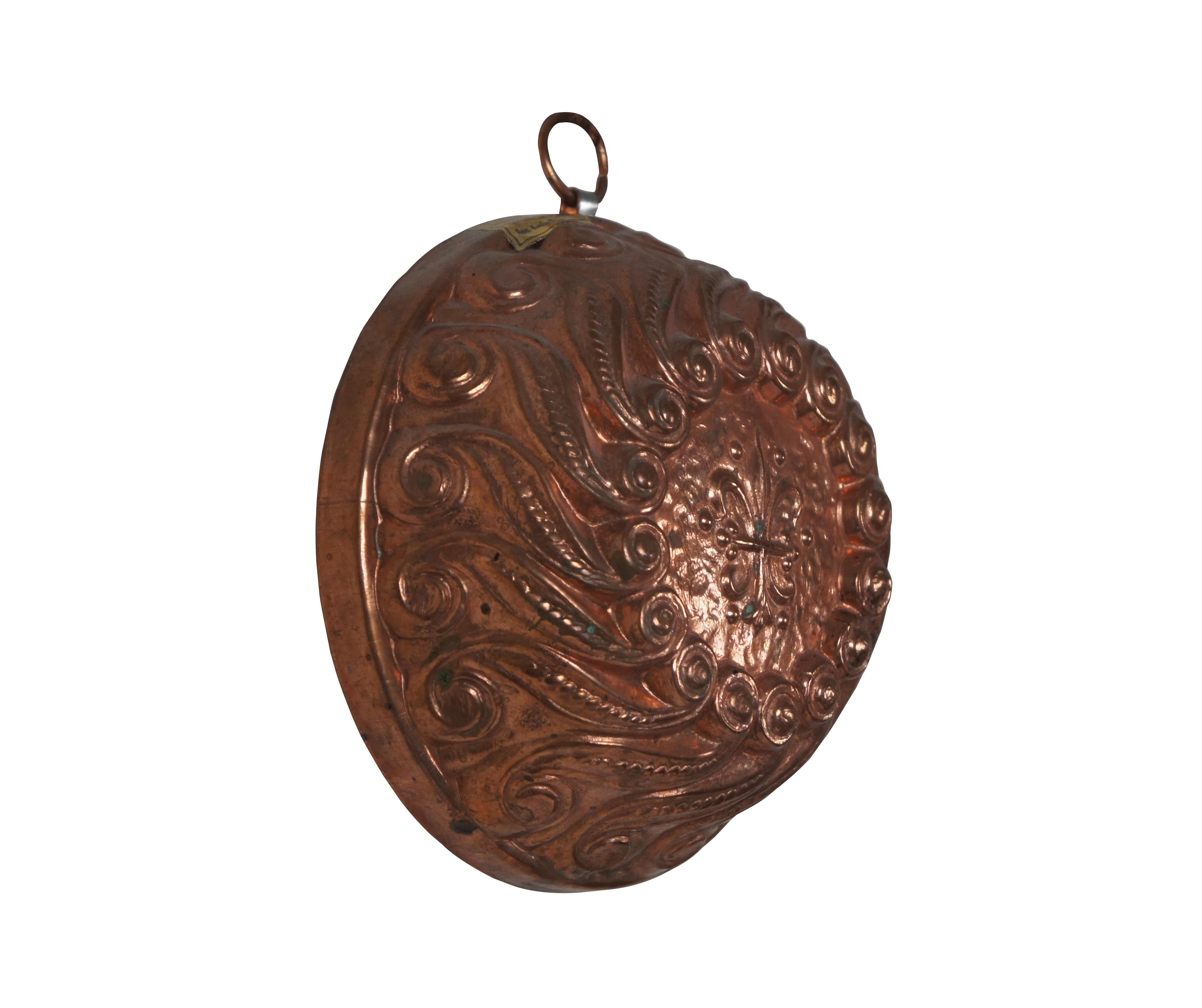 Vintage baking / pudding / jelly / chocolate mold by Birth-Gramm. Swiss made solid copper with tin lining and copper hanging ring. Round form decorated with a motif of what appear to be pea pods with scrolling tips and top emblazoned with a fleur de