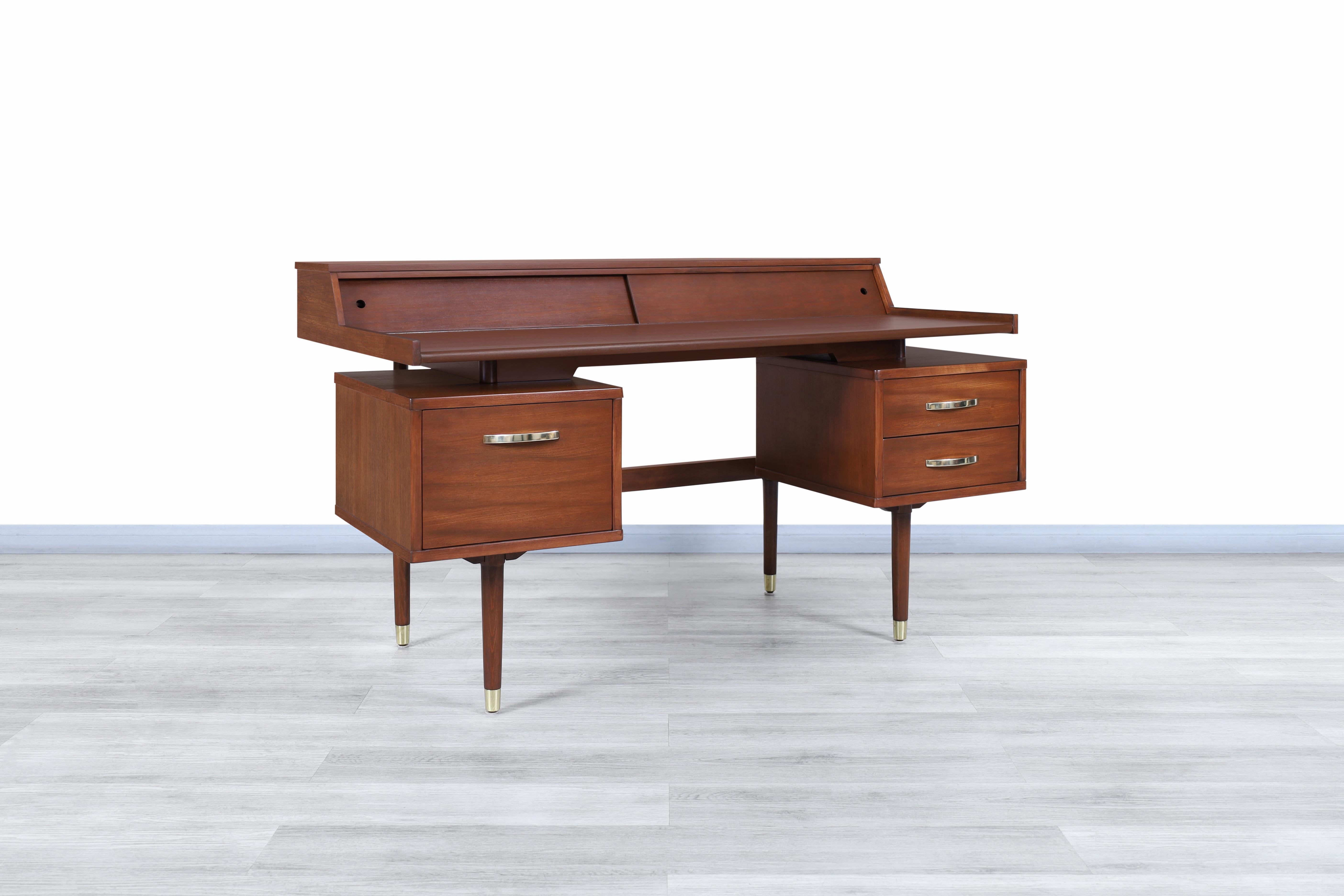 Wonderful vintage “Biscayne” floating top walnut desk by Drexel and manufactured in the United States, circa 1960s. This desk has been built from the highest quality walnut wood and stands out for its versatile and innovative design. This iconic