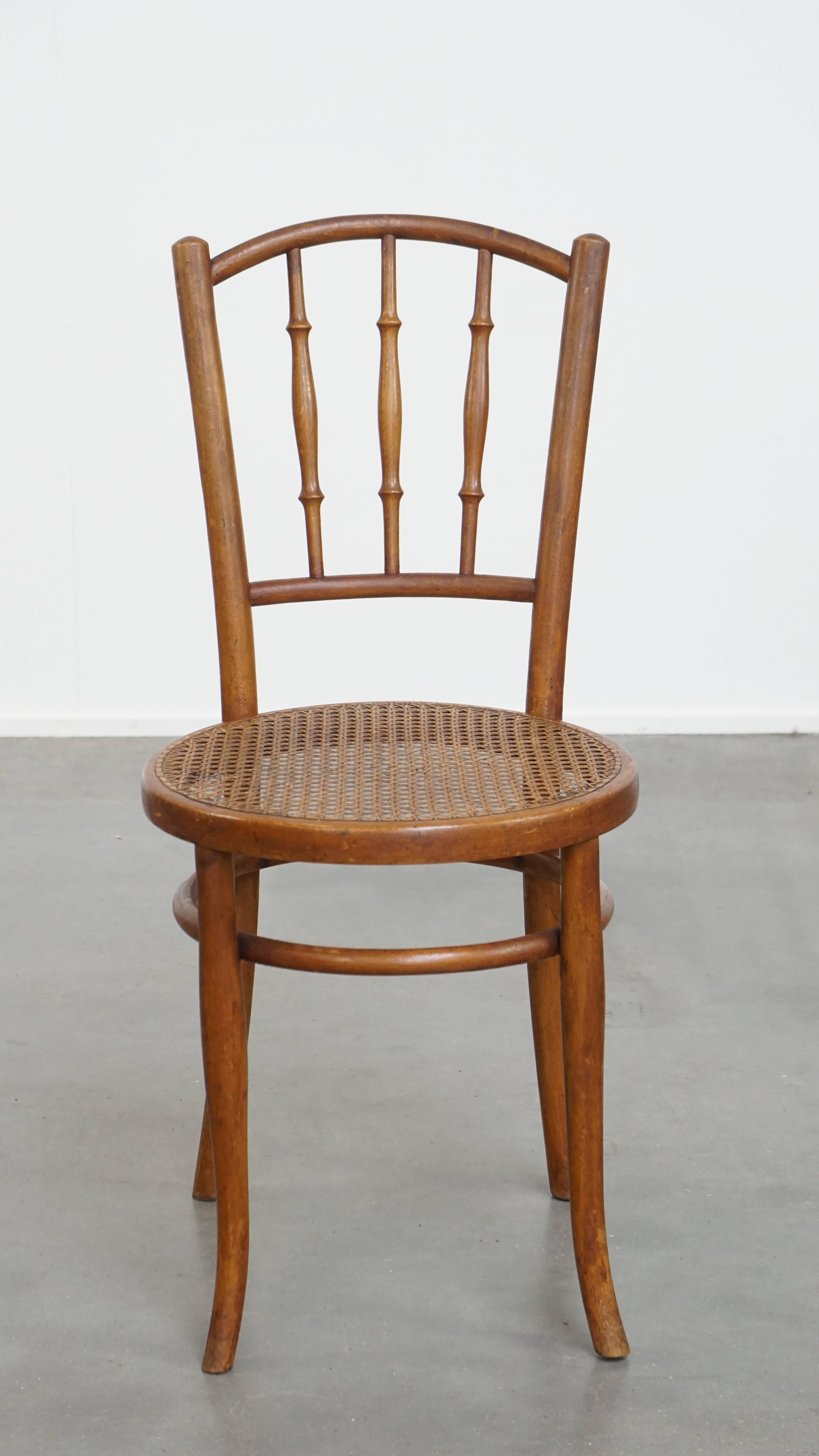 This charming vintage bistro chair in the style of Thonet, featuring a woven seat. This original bistro chair was produced by Fischel, based on a design by Thonet. It has beautiful wooden spindles in the backrest and a woven seat.

This timeless
