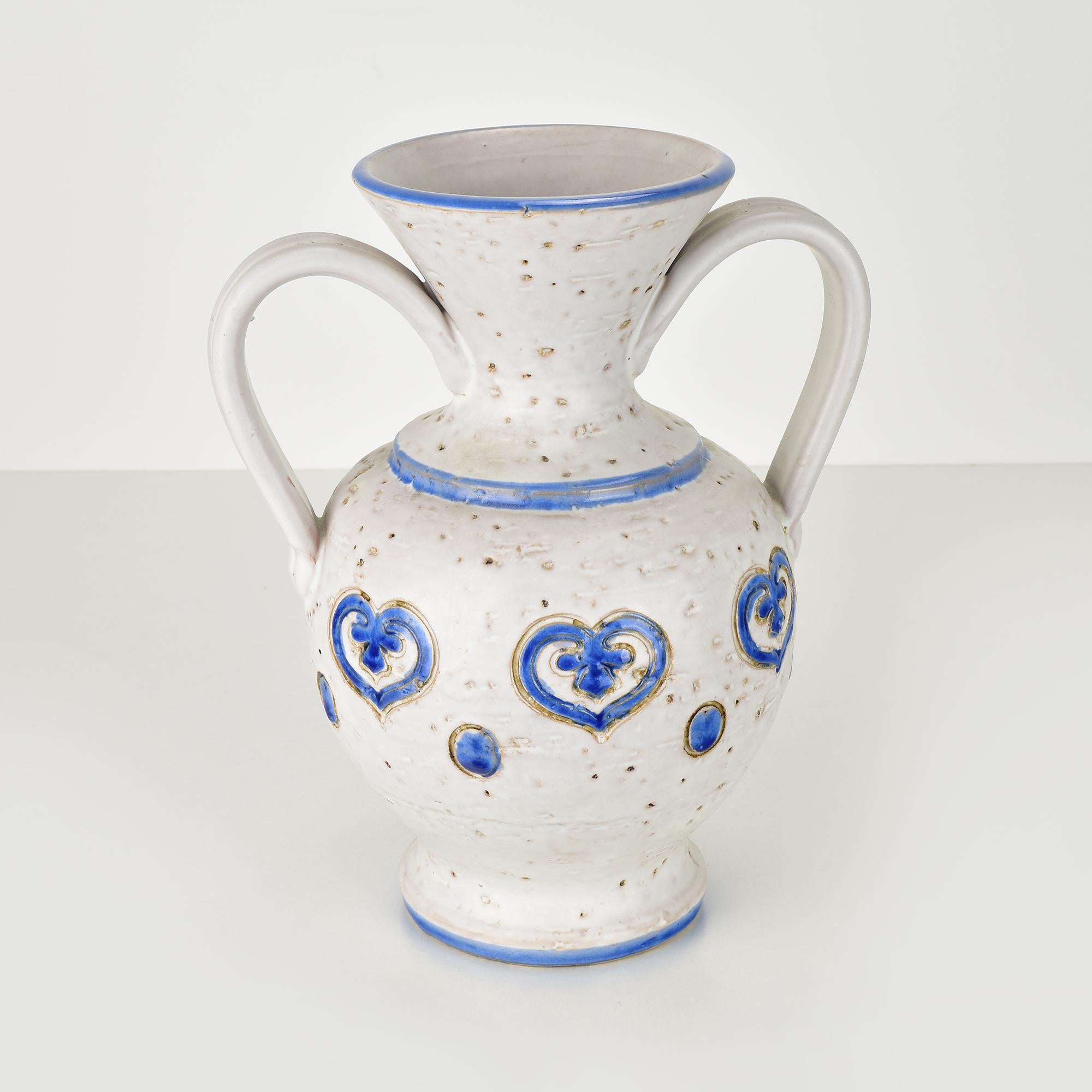 Ce superbe vase vintage Bitossi, conçu par Aldo Londi, met en valeur le motif emblématique des cœurs marocains. Artistics en céramique émaillée blanche avec des détails texturés et des accents bleus appliqués à la main, cette pièce incarne
