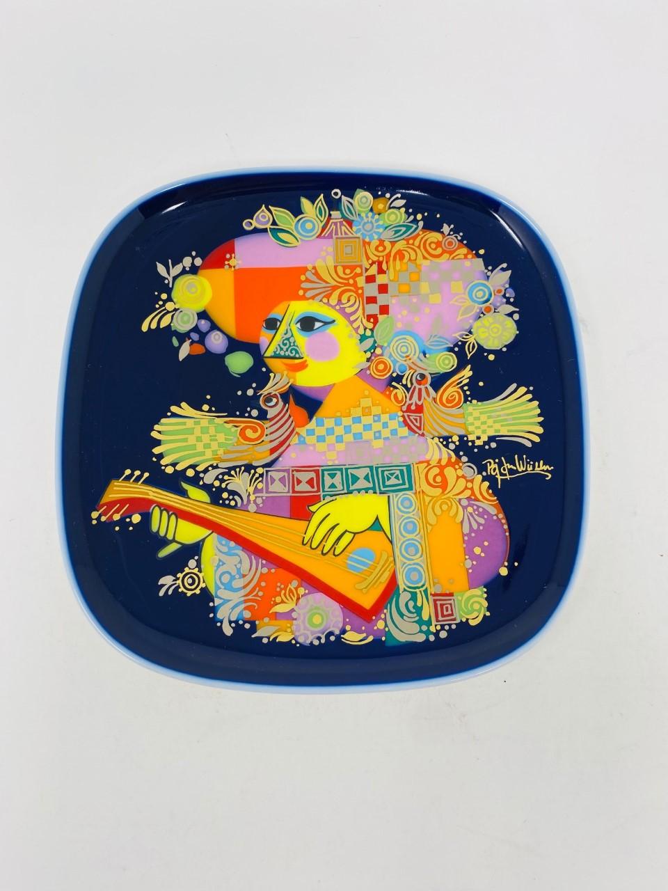Beautiful collectible plate from the famous Danish artist Bjorn Wiinblad (Bjørn Wiinblad). The plate was designed for Rosenthal, Germany and is decorated in saturated jewel tones on a glossy cobalt blue ground with gilt highlights. The back has the