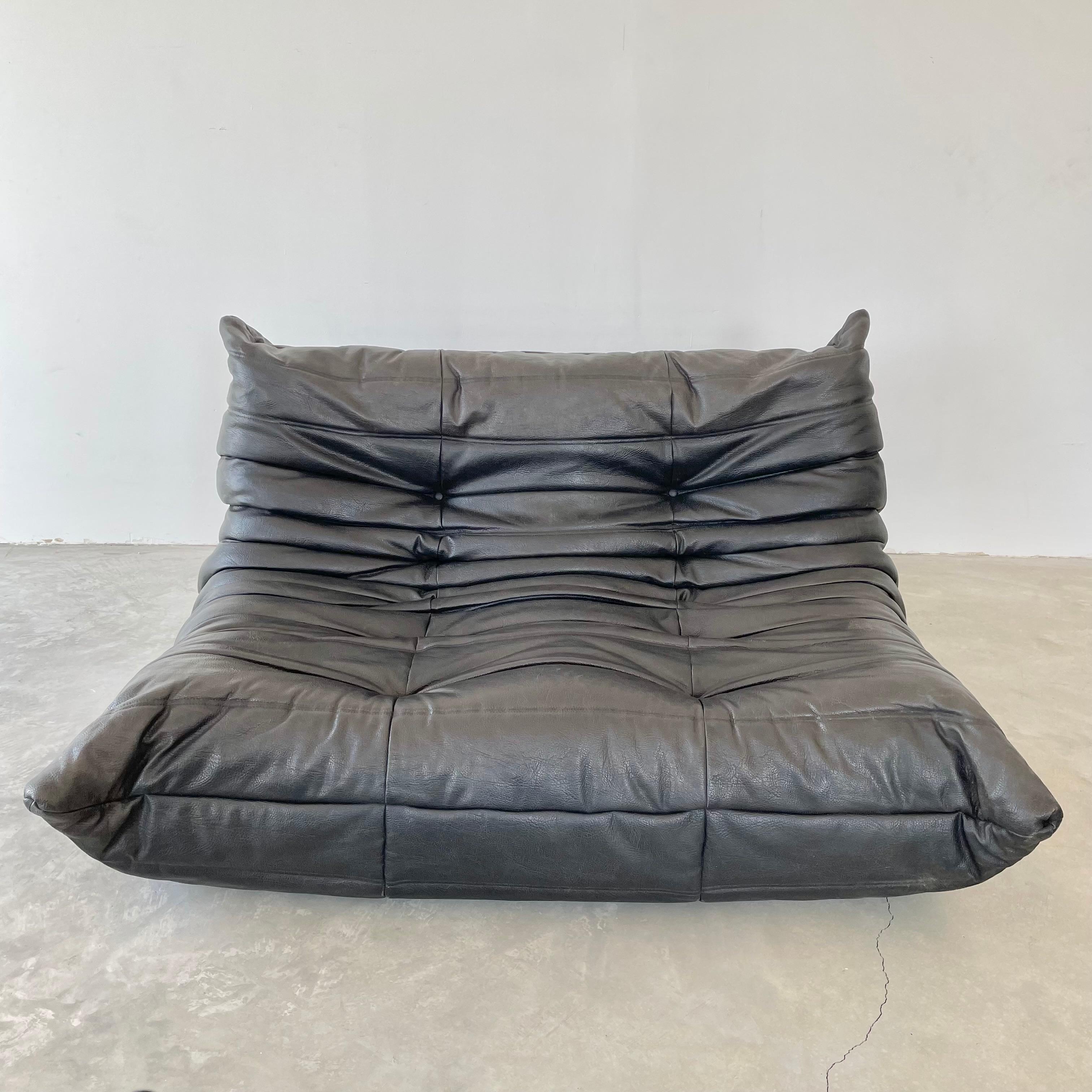 Classic French 2 seat Togo sofa by Michel Ducaroy for luxury brand Ligne Roset. Originally designed in the 1970s the iconic togo sofa is now a design classic. This sofa comes in its original vintage pebbled black leather.

Timeless comfort and