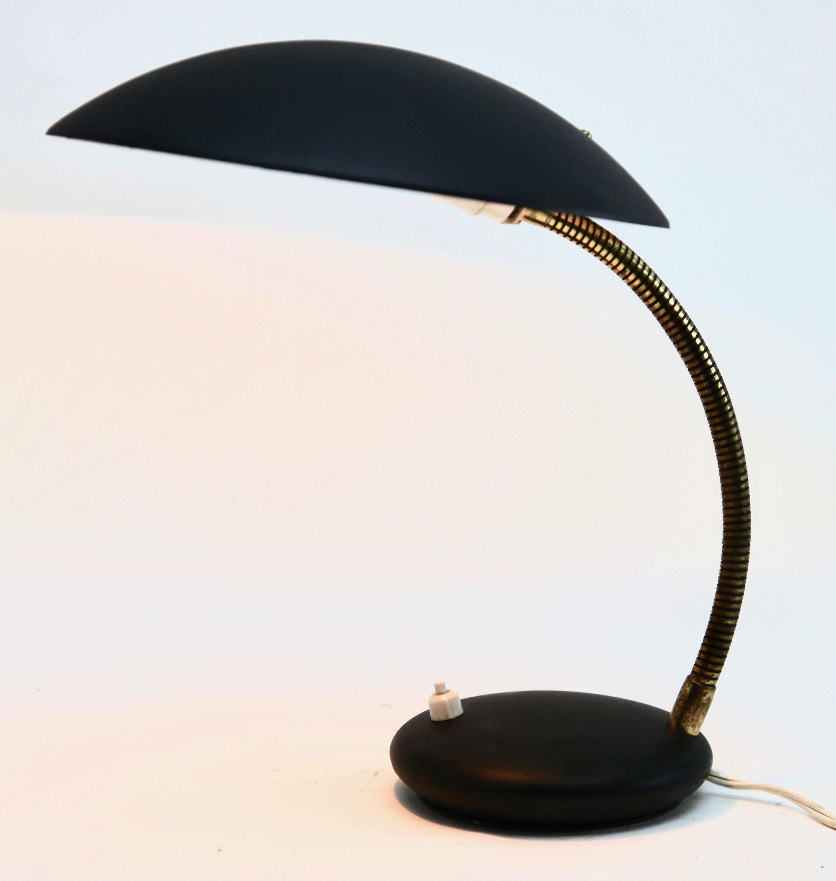 Classic compact design by Louise Kalff, this adjustable spotlight desk lamp was produced by Philips the 1970s.
The stand is metal and the flexible arm has brass patina, the lamp is fully original and in good condition
and has been left